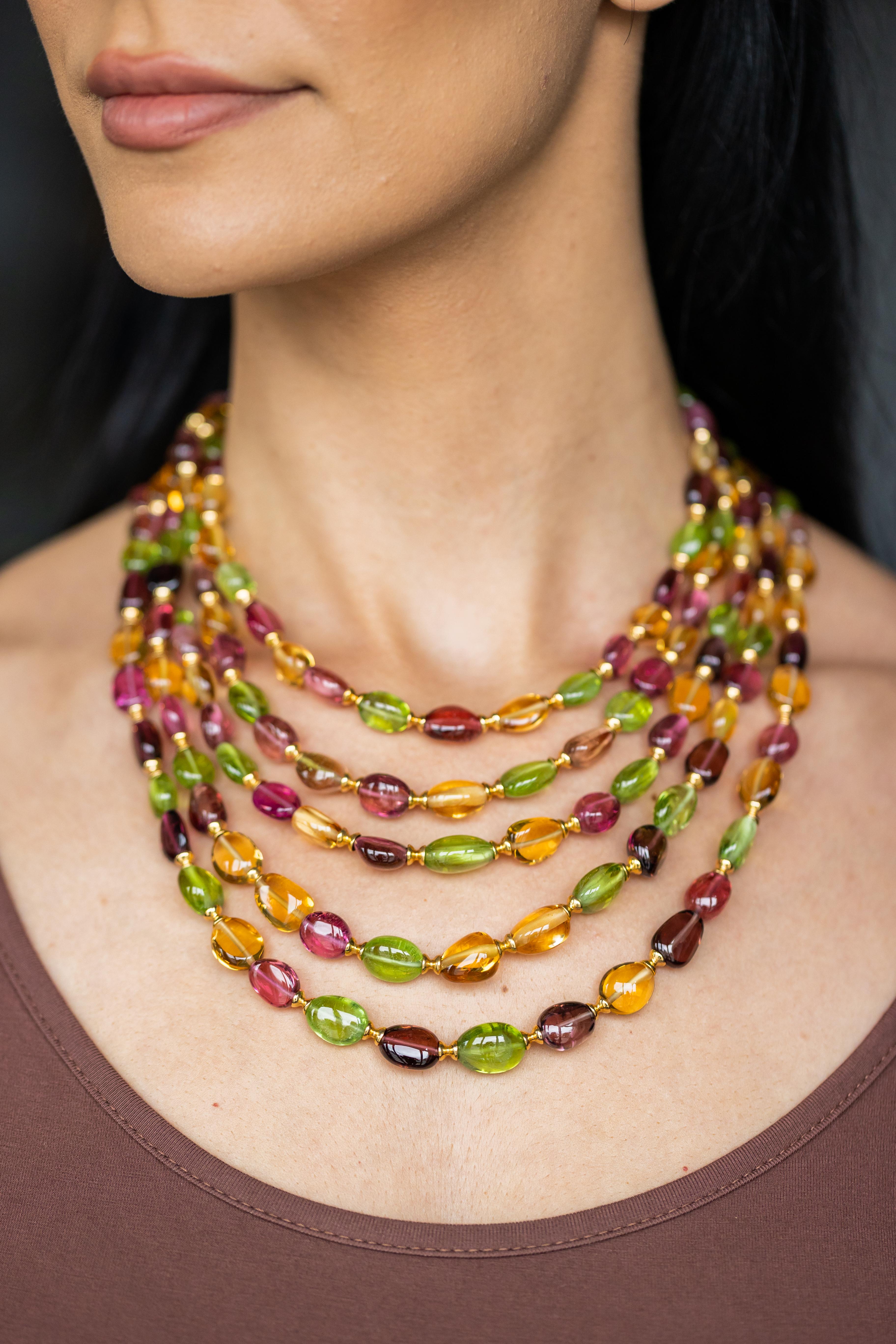 Laissez-vous séduire par la beauté envoûtante de ce collier exquis à cinq brins, un chef-d'œuvre des designers estimés de Syna. Cette pièce luxueuse est composée d'un ensemble de perles de tourmaline multicolore, de péridot vibrant et de citrine