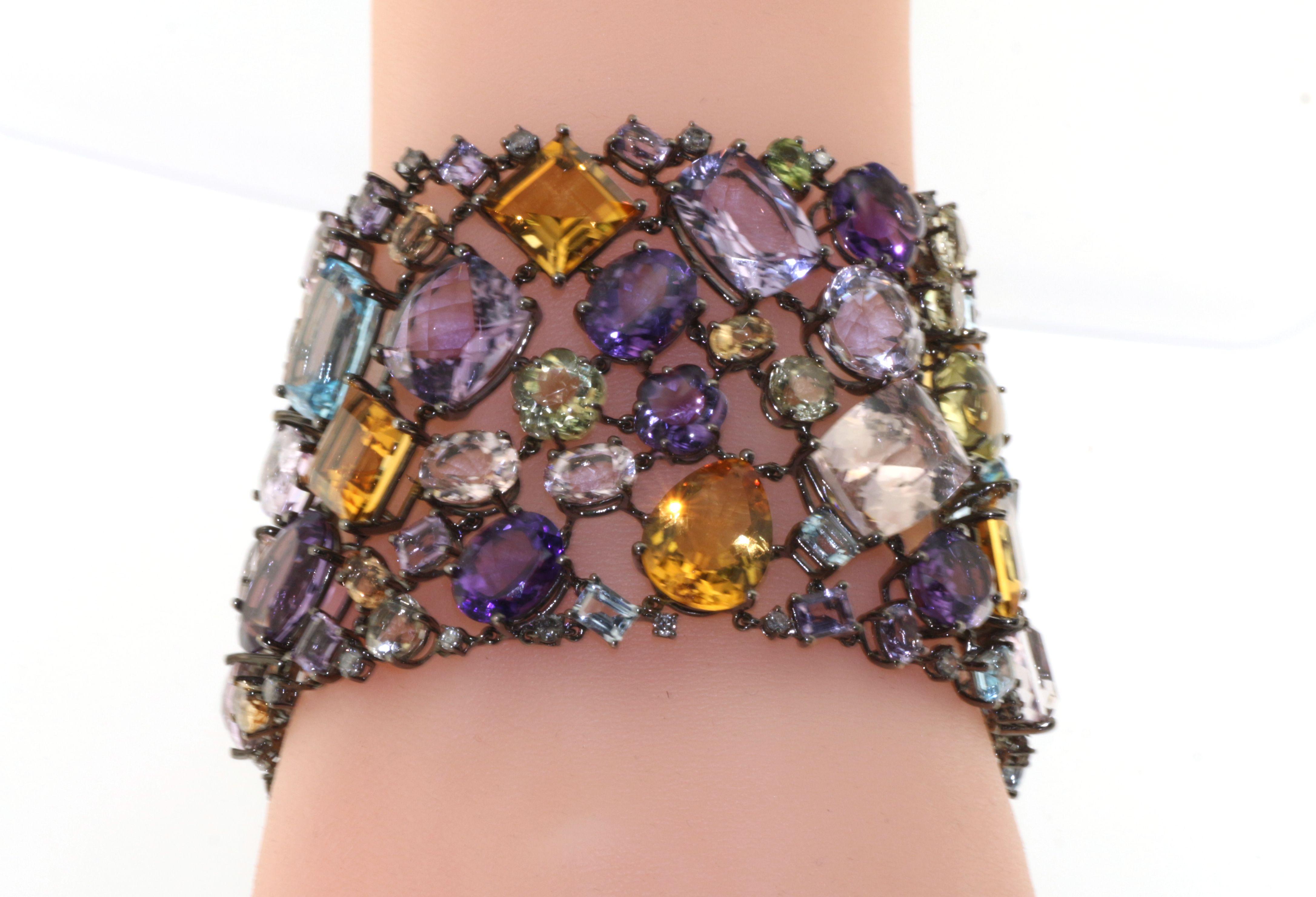 This bracelet features 212.54 carats of semi-precious ,Blue topaz, Kunzite, Amethyst, Aquamarine, Rose quartz ,Morganite and lenom quartz, and 2.60 carats of white round diamonds.  This piece is handmade in 18K Yellow gold.
Semi-Precious 212.54