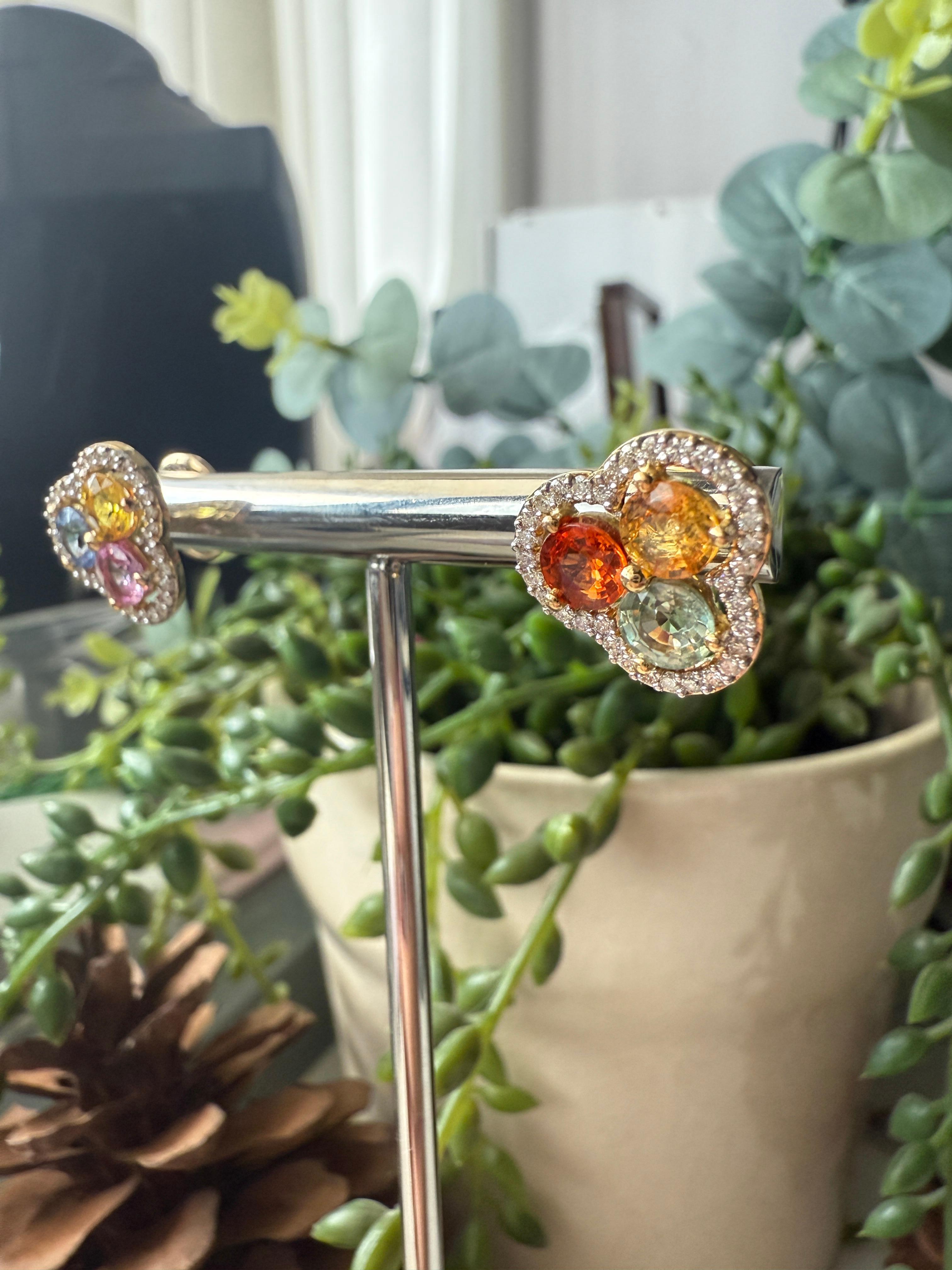 In times of abundant rain, dormant seeds awaken, and the horizon becomes a vibrant tapestry of wildflowers in full bloom. Capturing the essence of this breathtaking display, these African Daisy Earrings are a bouquet of multicolored sapphires set in