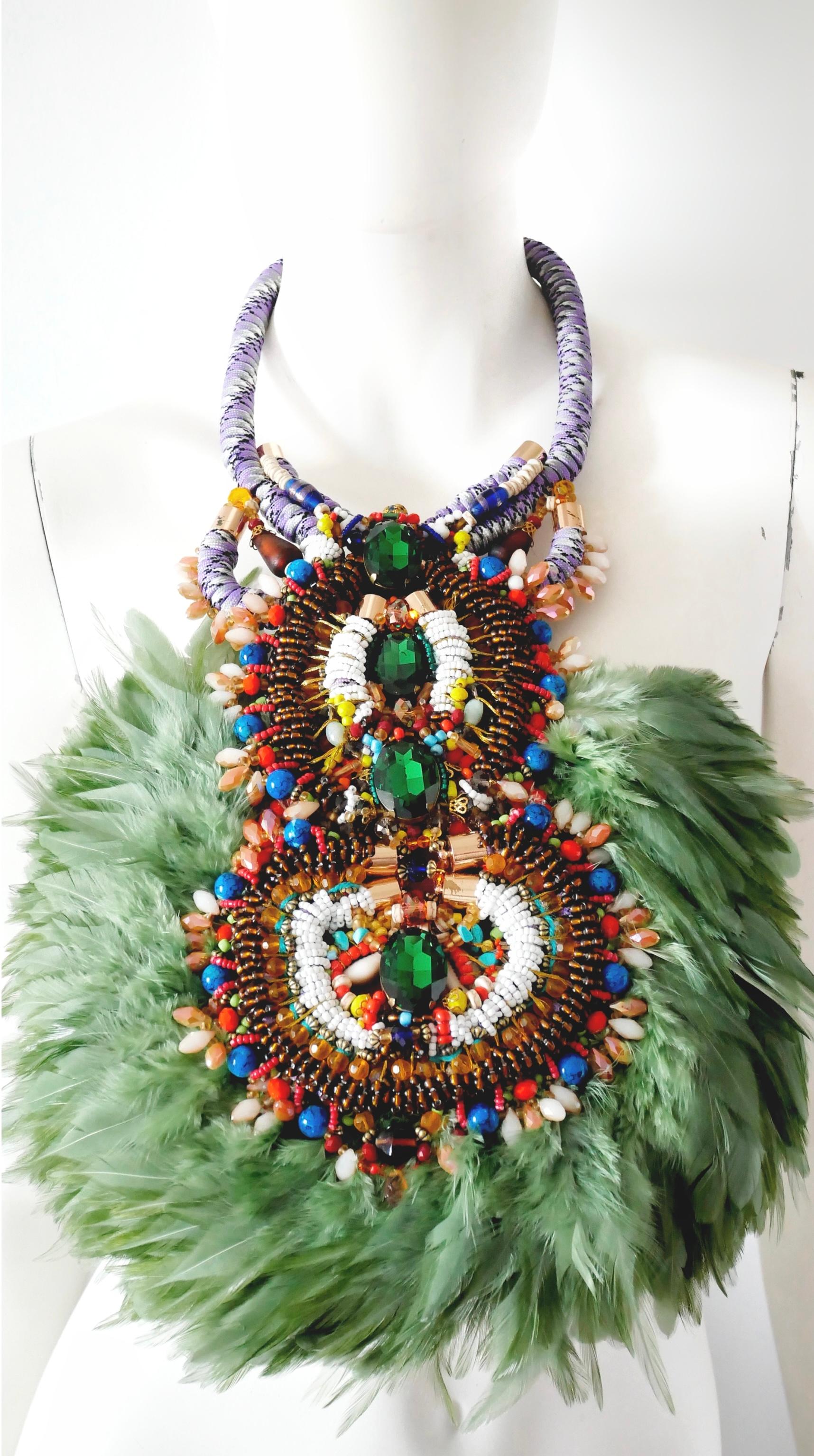 A magnificent blend of drama and luxury, this Multi-Coloured Glass Beaded and  Swarovski Crystal Feather Pendant Bib Necklace stands apart in its design. An eye-catching array of glass beads in a range of colours, shapes and sizes is complemented by