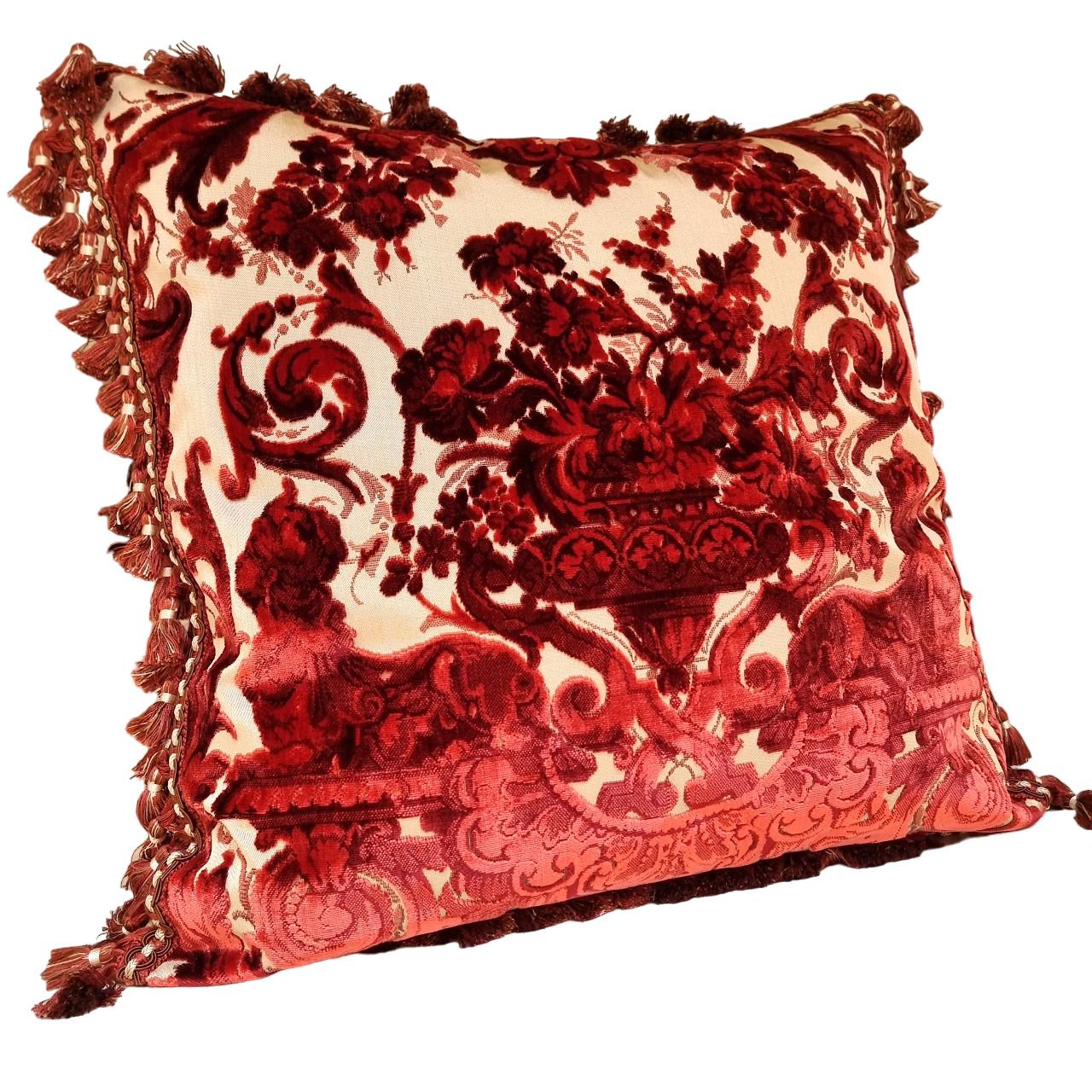 This amazing decorative throw pillow is handmade using Luigi Bevilacqua silk velvet - Grottesche pattern, 19th-century design - in red multi-colour on beige background embellished with red and ivory tassel fringe all along the four edges, the back