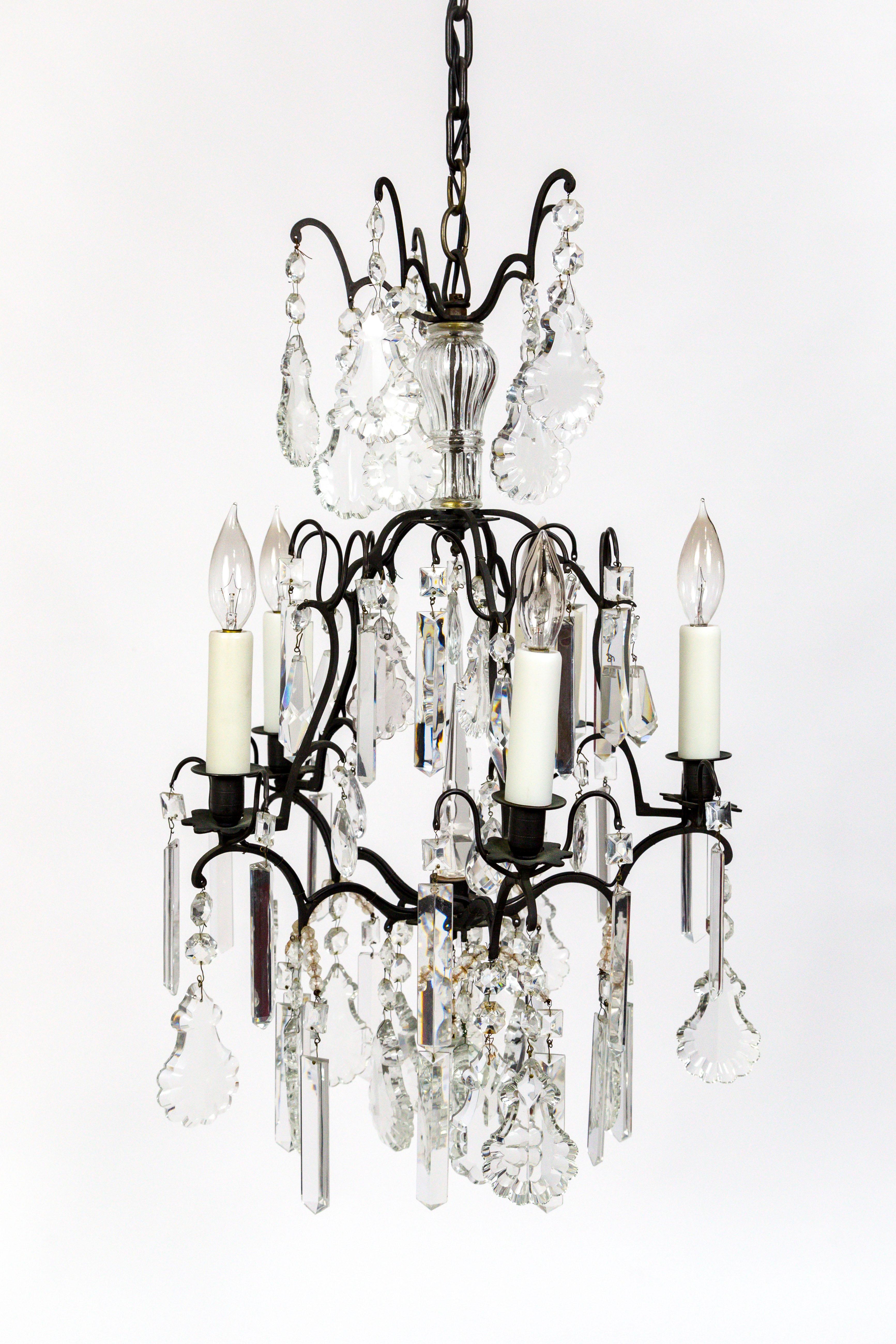 A beautiful pair of black toned bronze, birdcage style chandeliers. They are decked with numerous crystal types: colonial drops, almond, short drop, X-prism, pearl, spear, pendeloque, octagon, and square stone, American, 1920s. Measures: 44