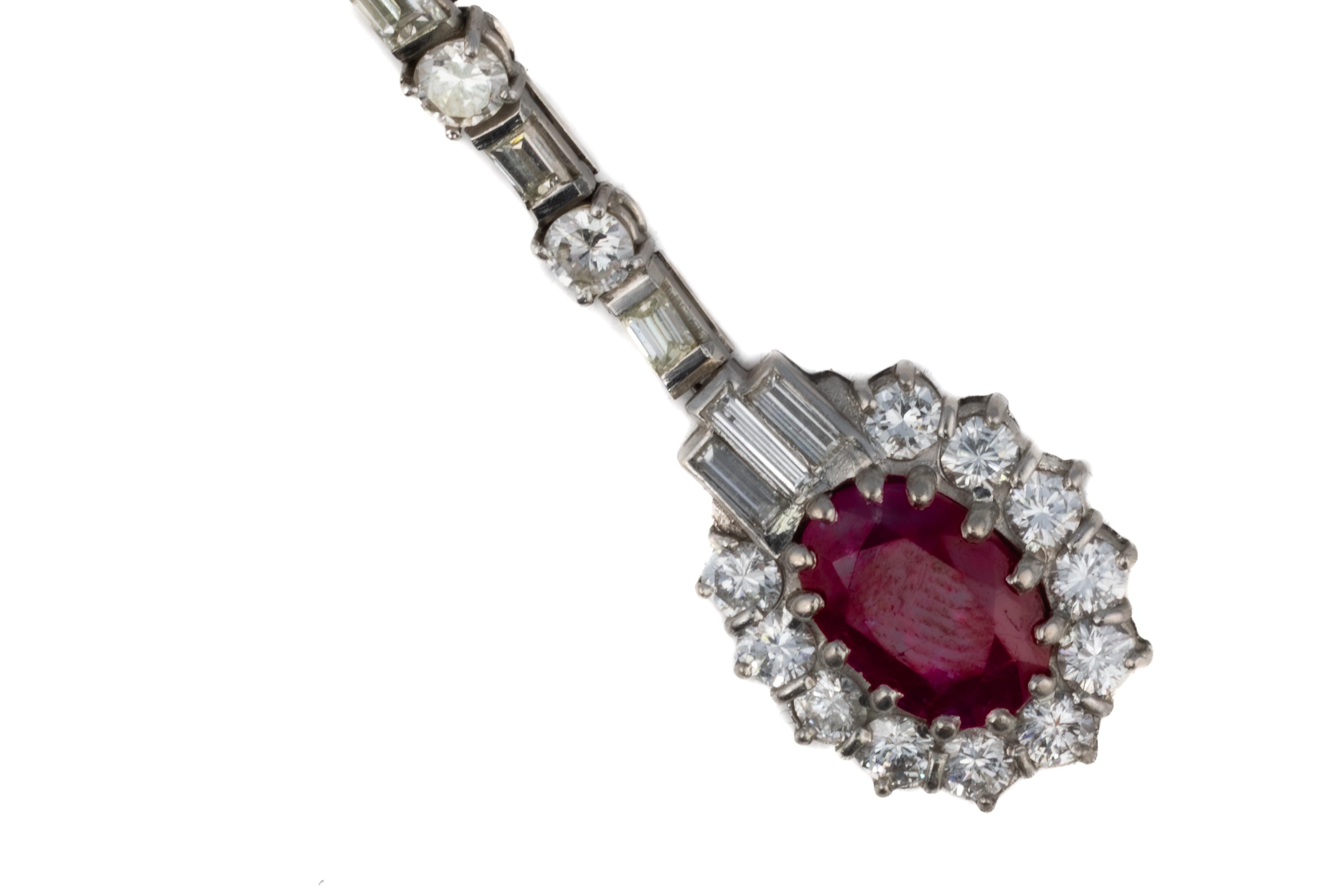 Multi Cut Diamond & Ruby Drop Earrings

Description:
A refined pair of ruby and diamond drop earrings showcasing vibrant oval-cut rubies surrounded by a halo of round brilliant and baguette-cut diamonds. The articulated drop is designed with