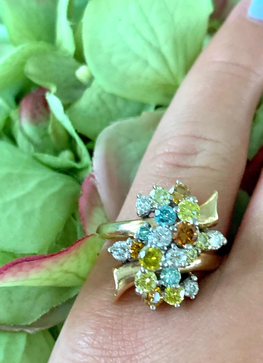 This fabulously unique ring features colored diamonds in a playful yellow gold setting.

White and irradiated diamond waterfall ring features diamonds in clear, blue, yellow and orange. 
There are 20 full cut diamonds approximately 1.75 carat total