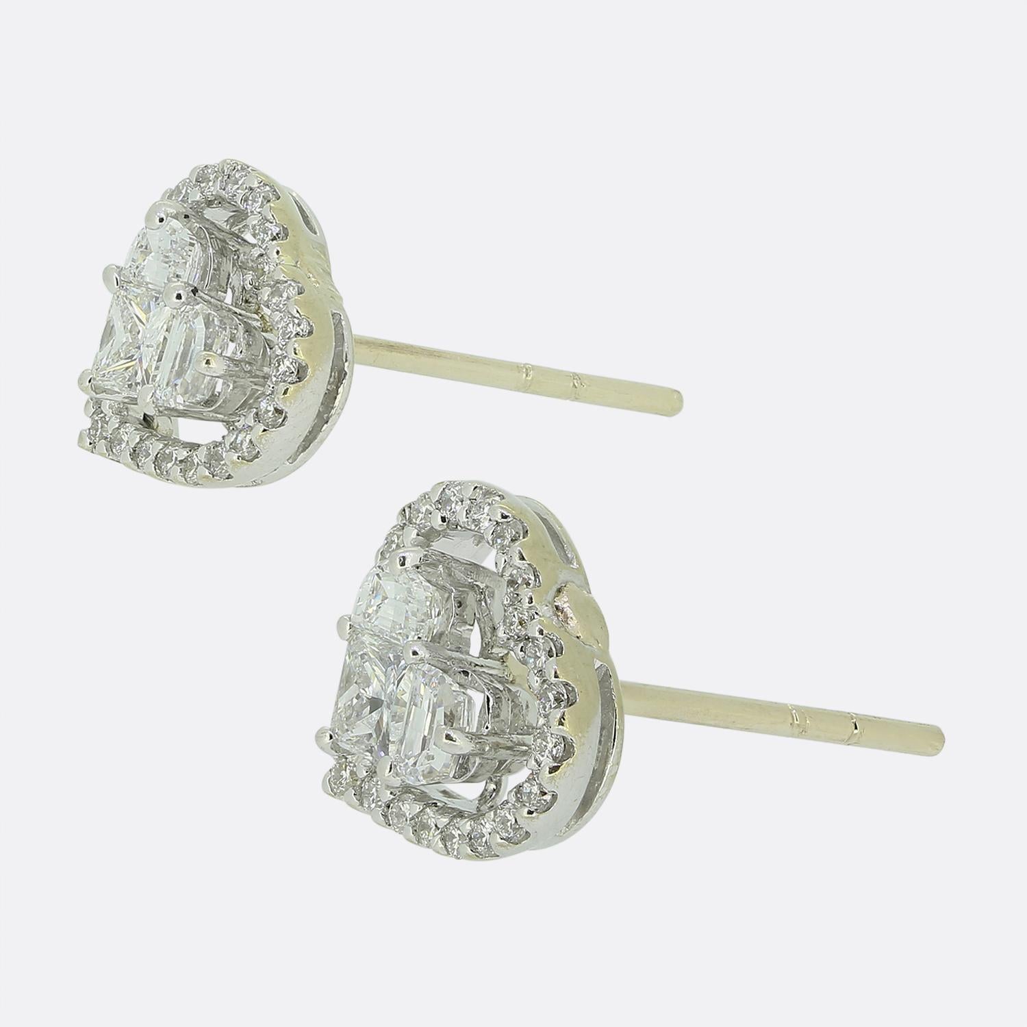 Aquí tenemos un par de pendientes de diamantes en forma de corazón. Cada pendiente lleva un diamante central de talla princesa coronado por dos diamantes de talla media luna. Una montura en forma de corazón formada por una única fila de diamantes