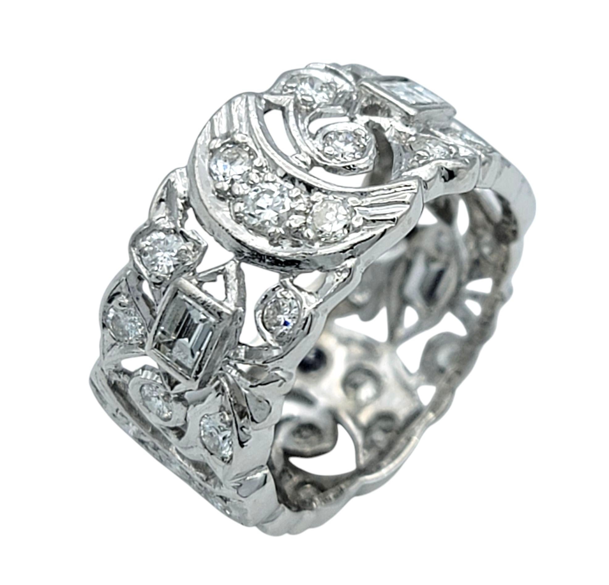 Ring Size: 6.5 

This stunning platinum diamond band is a masterpiece of intricate craftsmanship, blending vintage charm with timeless sophistication. The wide band is adorned with an elaborate filigree design, featuring delicate scrollwork and