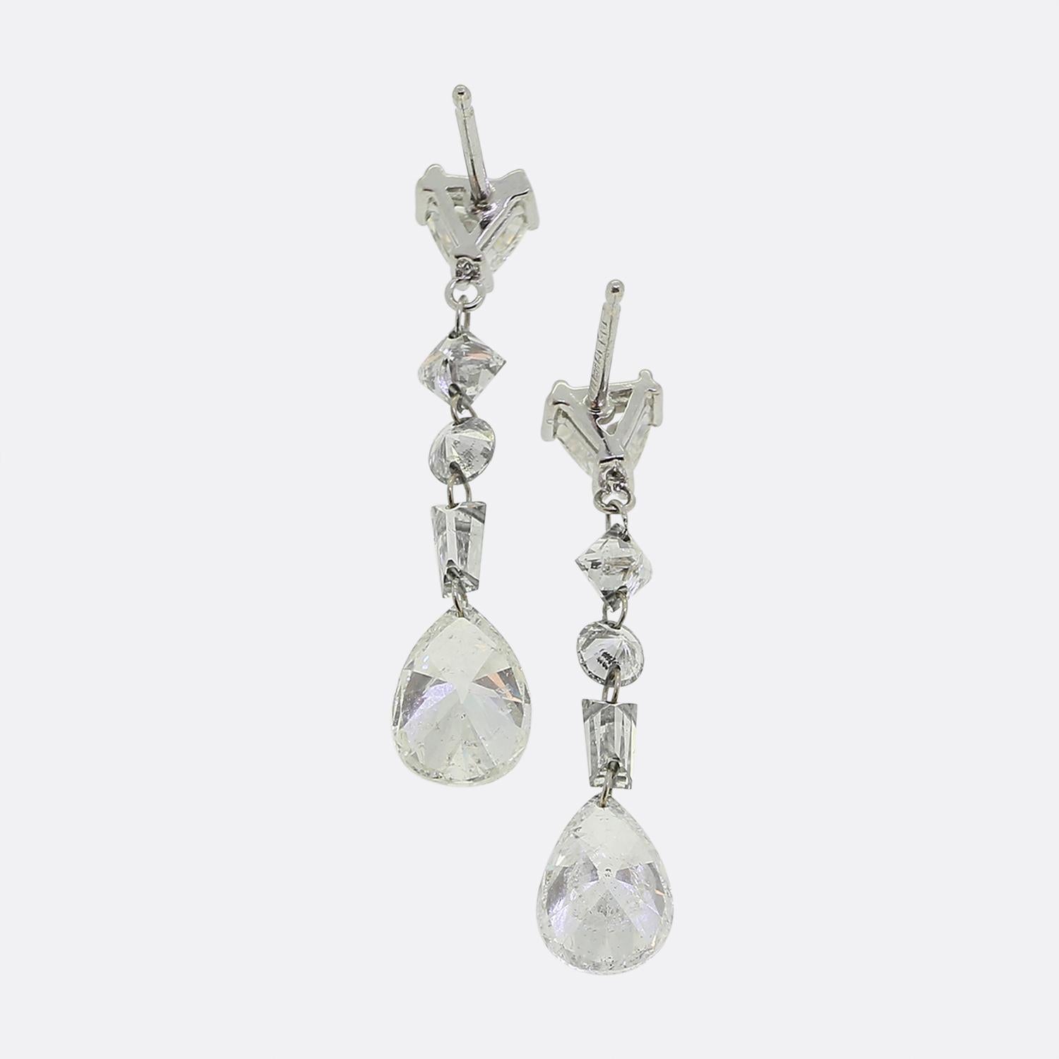 Here we have a stunning pair of 14ct white gold diamond drop earrings. Each identical piece features a shimmering pear-cut diamond as the primary stone, elegantly suspended at the very bottom. Above, a series of white diamonds in various cuts,