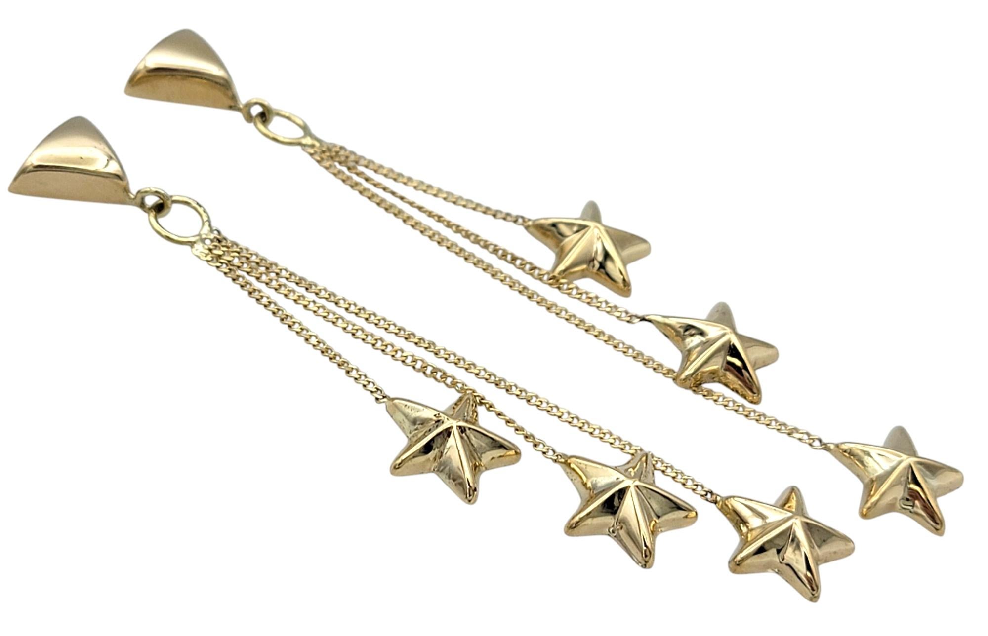 Celestial elegance meets artistic design in these captivating star dangle earrings, crafted in 14 karat yellow gold. Each earring features three separate dangles, gracefully cascading at varied lengths to create a mesmerizing sense of movement. At