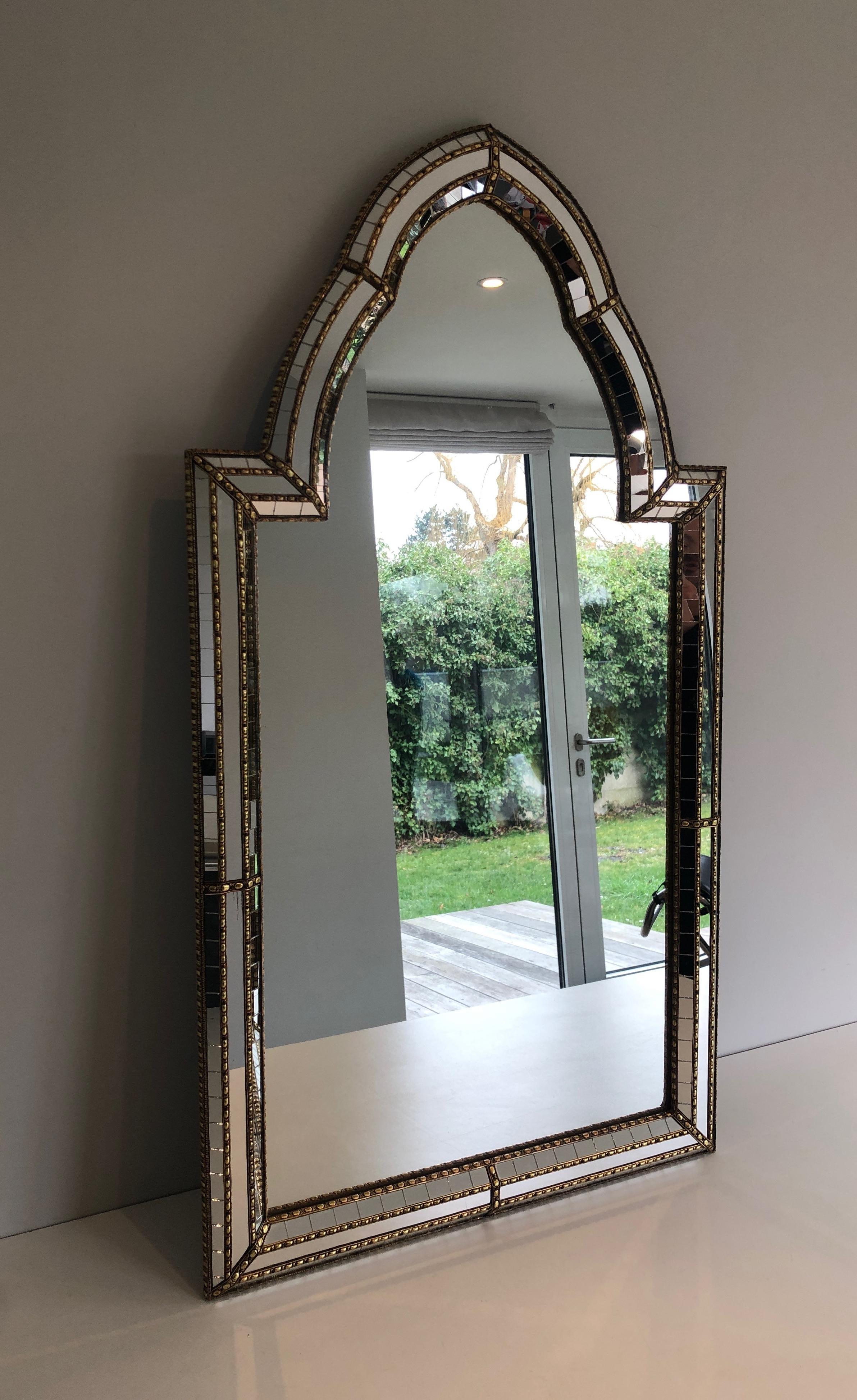 This decorative mirror is made of multi-facets mirrors with brass garlands. This is a French work, circa 1970.
