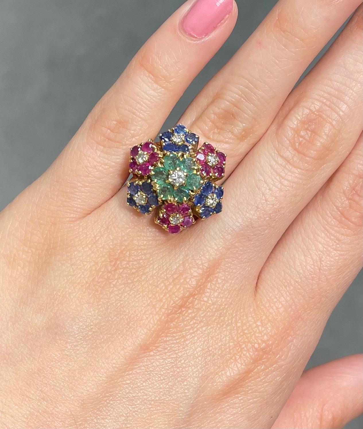 Multi Gem Floral Ring 

A French-made ring set with a cluster of 7 round cut diamonds, 6 emeralds, 15 rubies, and 15 sapphires.
 
Ring Size: 6 
Resizable free of charge
Metal Type: 18 Karat Yellow Gold

