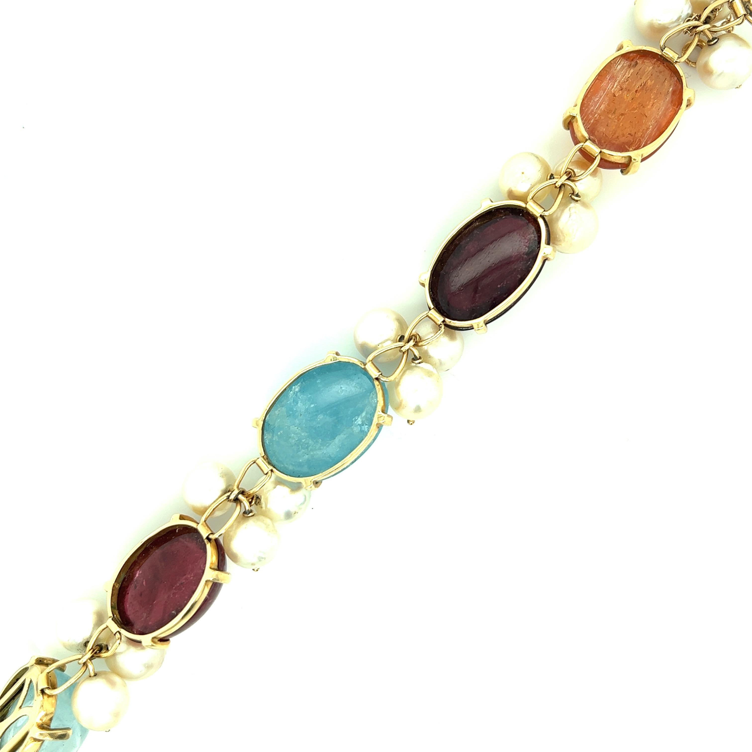 A 14 karat yellow gold bracelet featuring multiple gems, including citrine, tourmalines, and aquamarines. Marked: 14kt. Total weight: 52.1 grams. Inner circumference: 7.25 inches. 