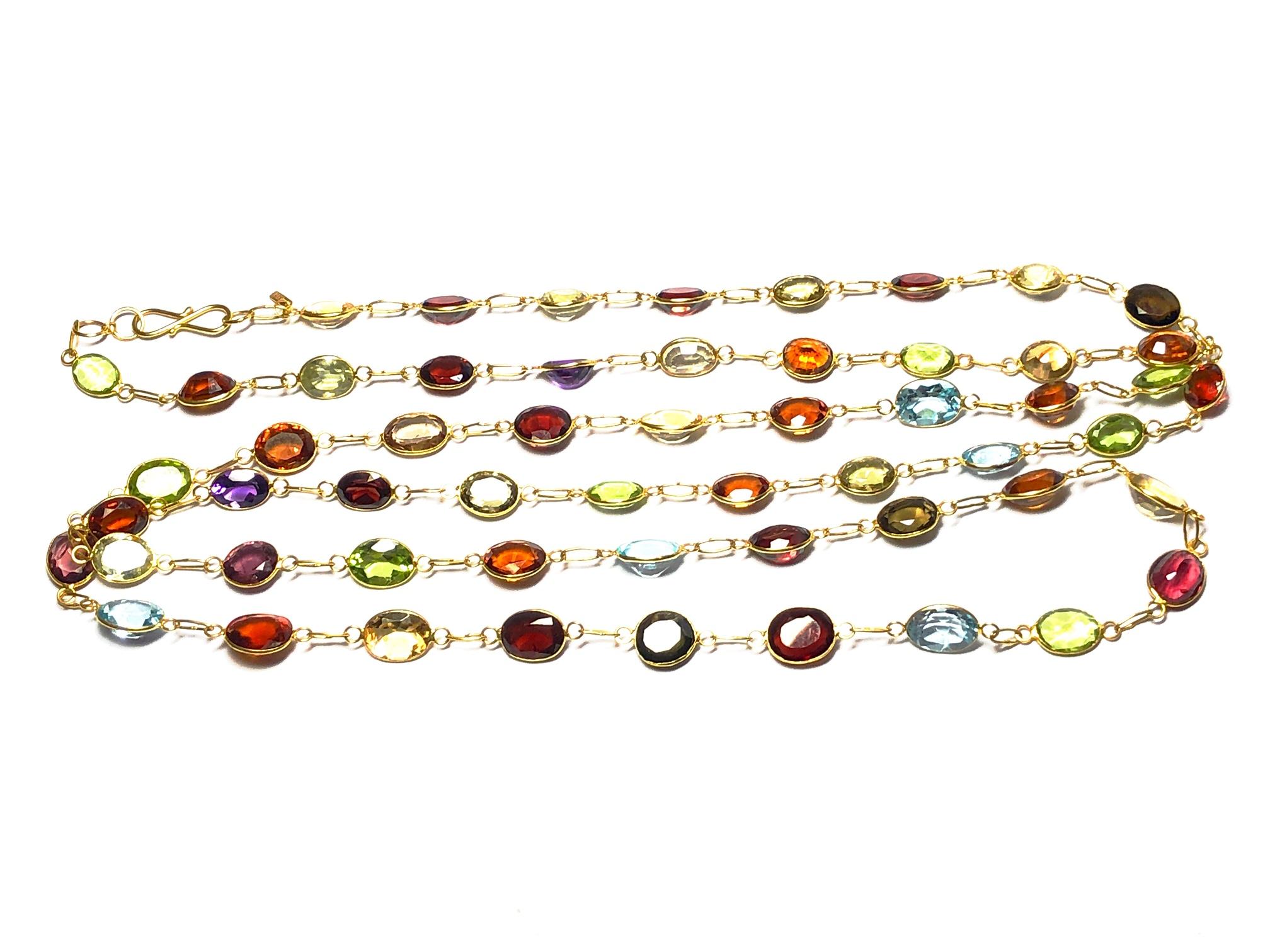 A Multi gem set necklace, with garnet, citrine, amethyst topaz and peridot, in a fine rubover setting, with chain link detail between, in 14ct yellow gold, with a figure of eight clasp, length approximately 90cm.
