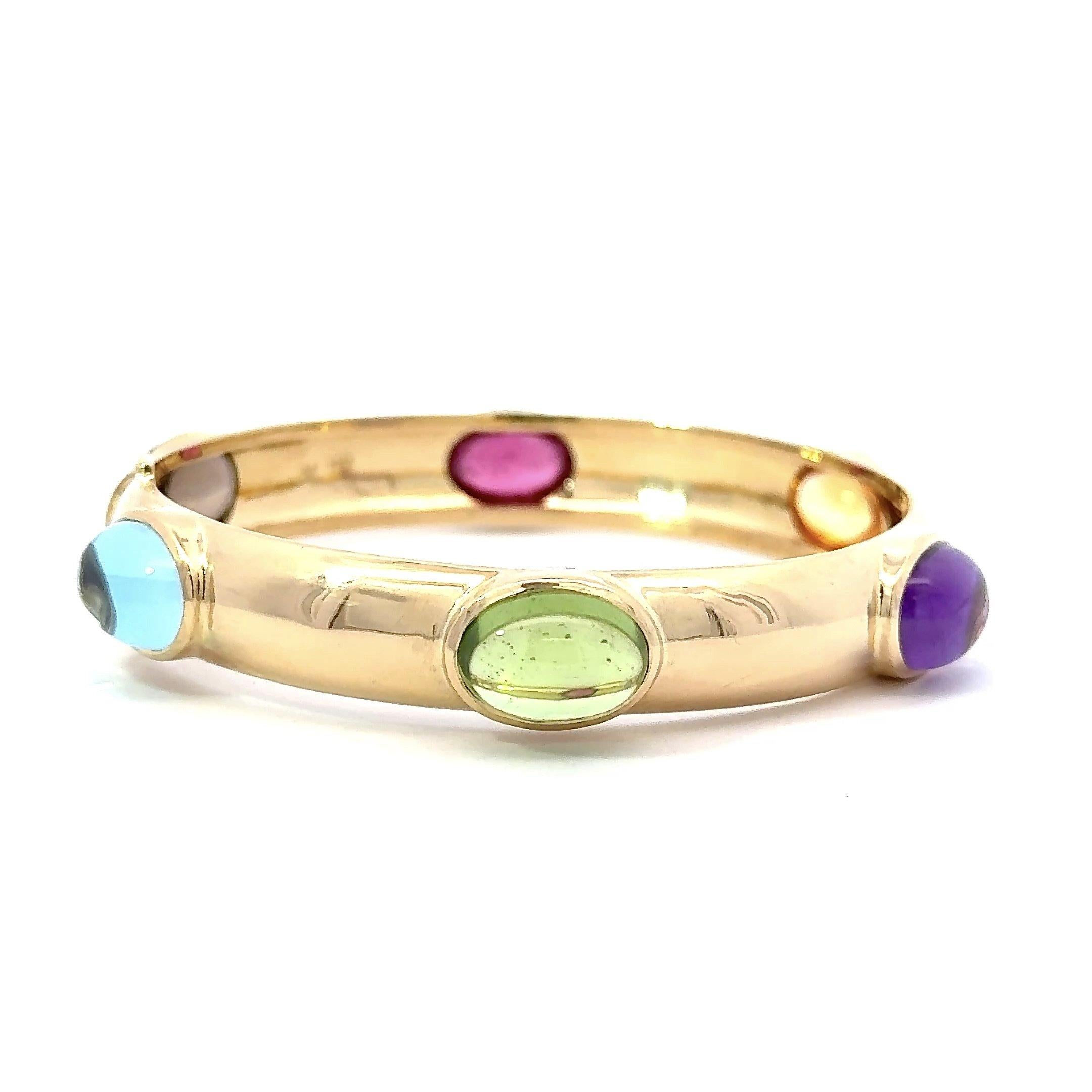 Stunning Multi Gemstone 1970's Bangle Bracelet 
Beautiful Oval Cabochon Peridot, Amethyst, Citrine, Pink Tourmaline, Smoky Quartz and Blue Topaz.
11.5mm Wide  
The Gemstones in The Bezels are 15mm x 11.5mm 
42.1 grams 18kt Gold
7.5