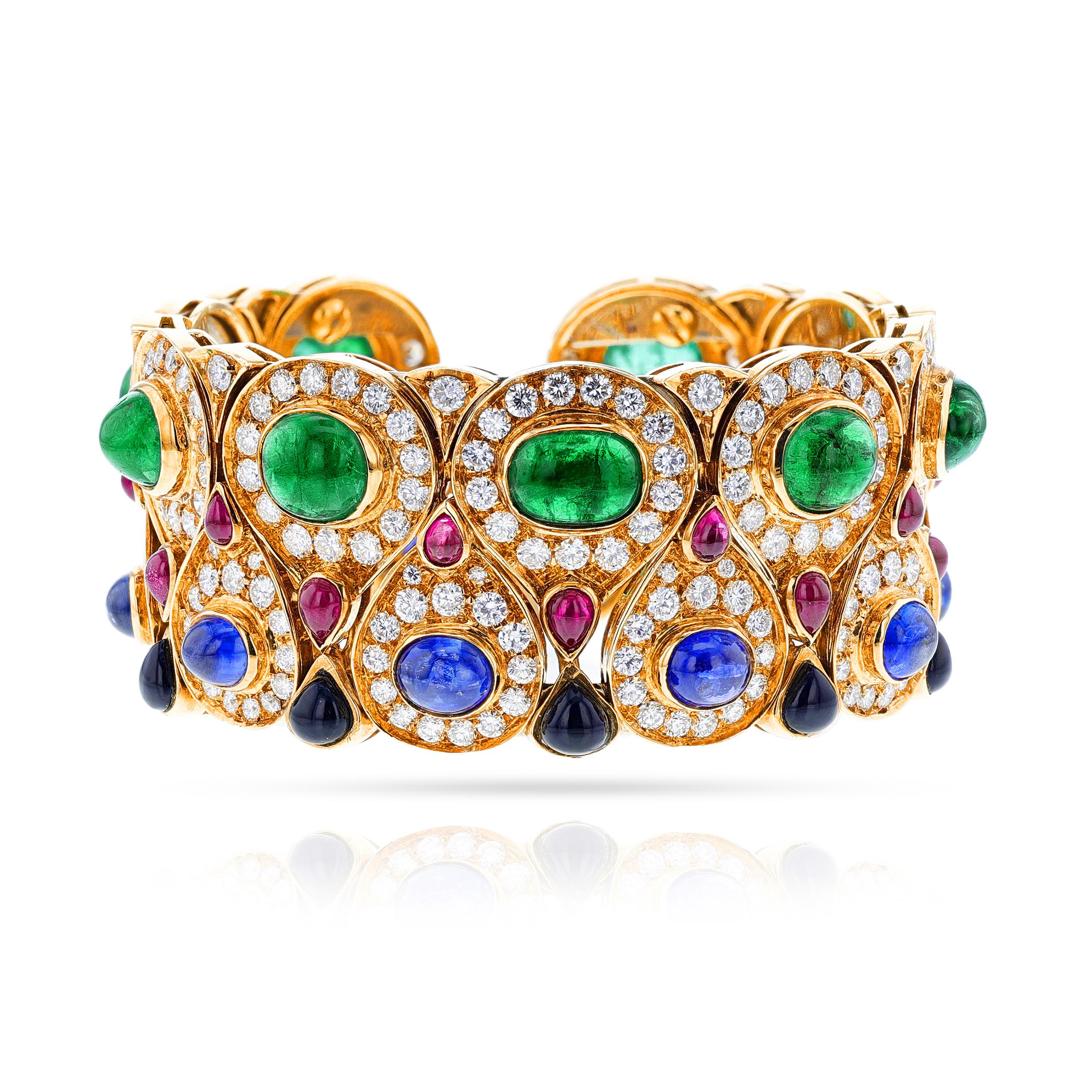 A Multi-Gemstone Bangle with Emeralds, Diamonds, Rubies, Sapphires and Onyx, 18k. There are oval emerald cabochons, oval saphire cabochons, round diamonds, with pear ruby cabochons, and pear shaped onyx. The emeralds weigh appx. 17 cts, the