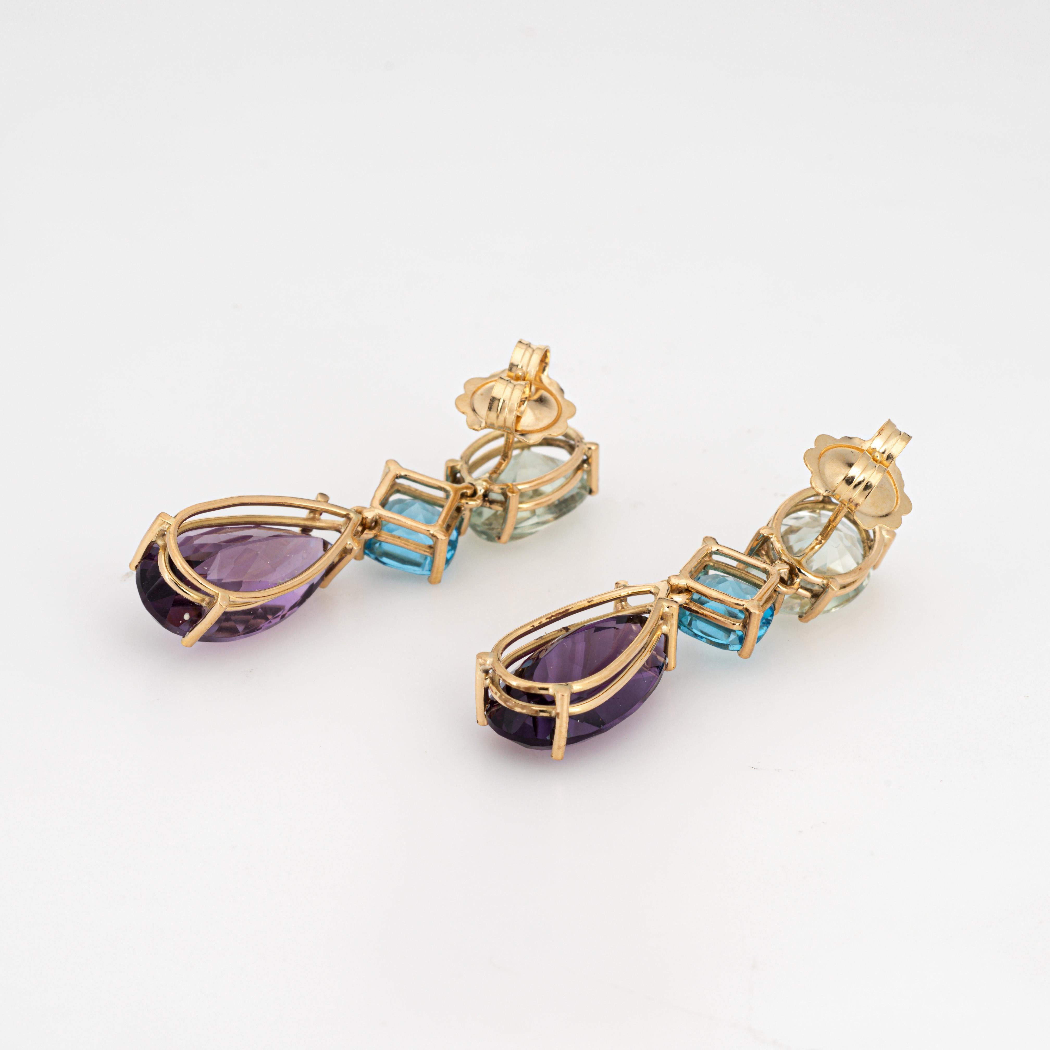 Elegant pair of multi gemstone drop earrings crafted in 18k yellow gold. 

Prasiolite measures 13mm x 9mm, blue topaz measures 8mm and amethyst measures 20mm x 10mm. The stones are in very good condition and free of cracks or chips. 

The 1 1/2 inch