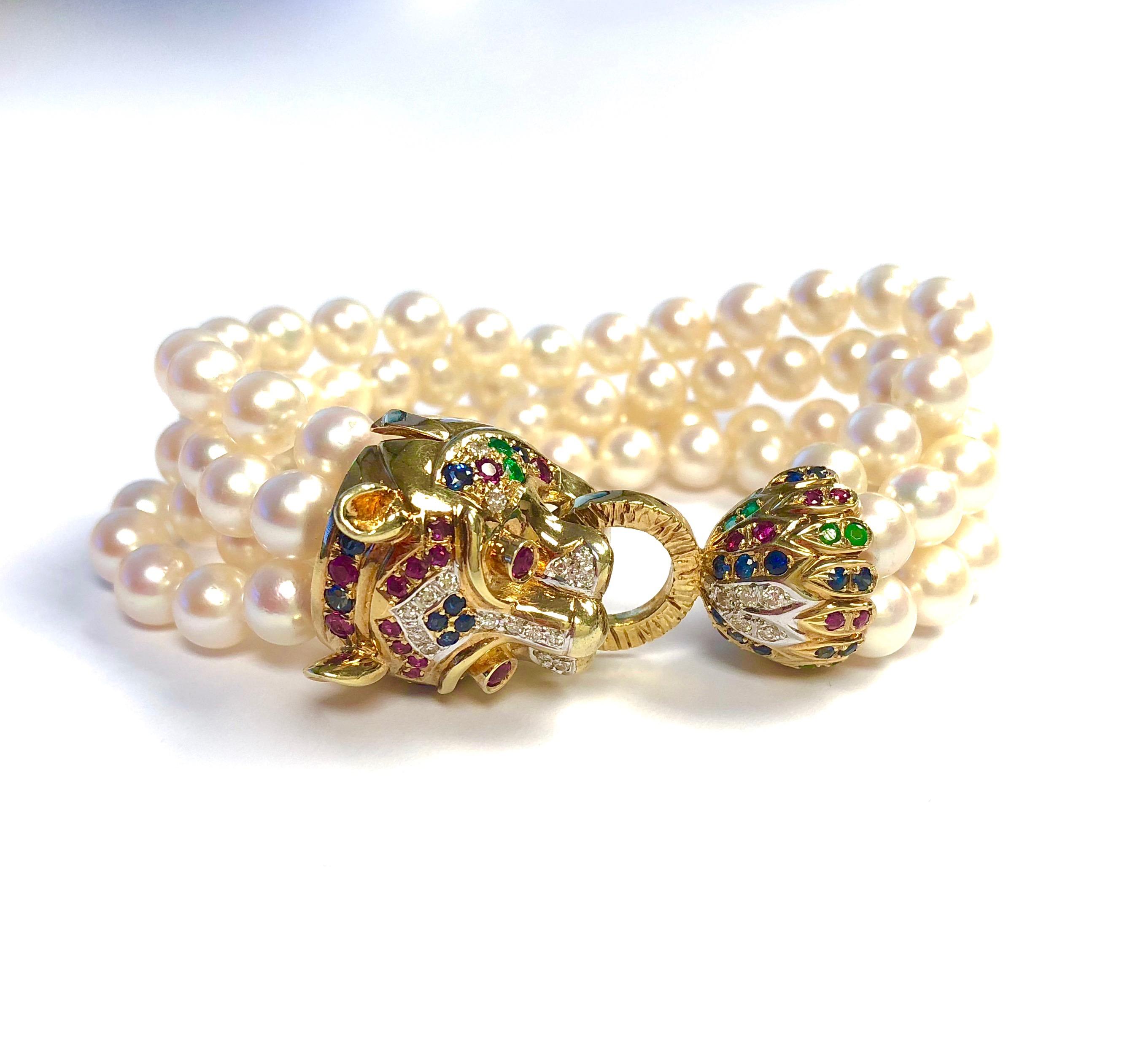 14K yellow gold panter clasp set with rubies, emeralds, sapphires and diamonds supported by four strands of 6.5mm to 7mm cultured Akoya pearls. The pearls have a high luster with rose over tone. 
24 round brilliant cut diamonds, approcimate total