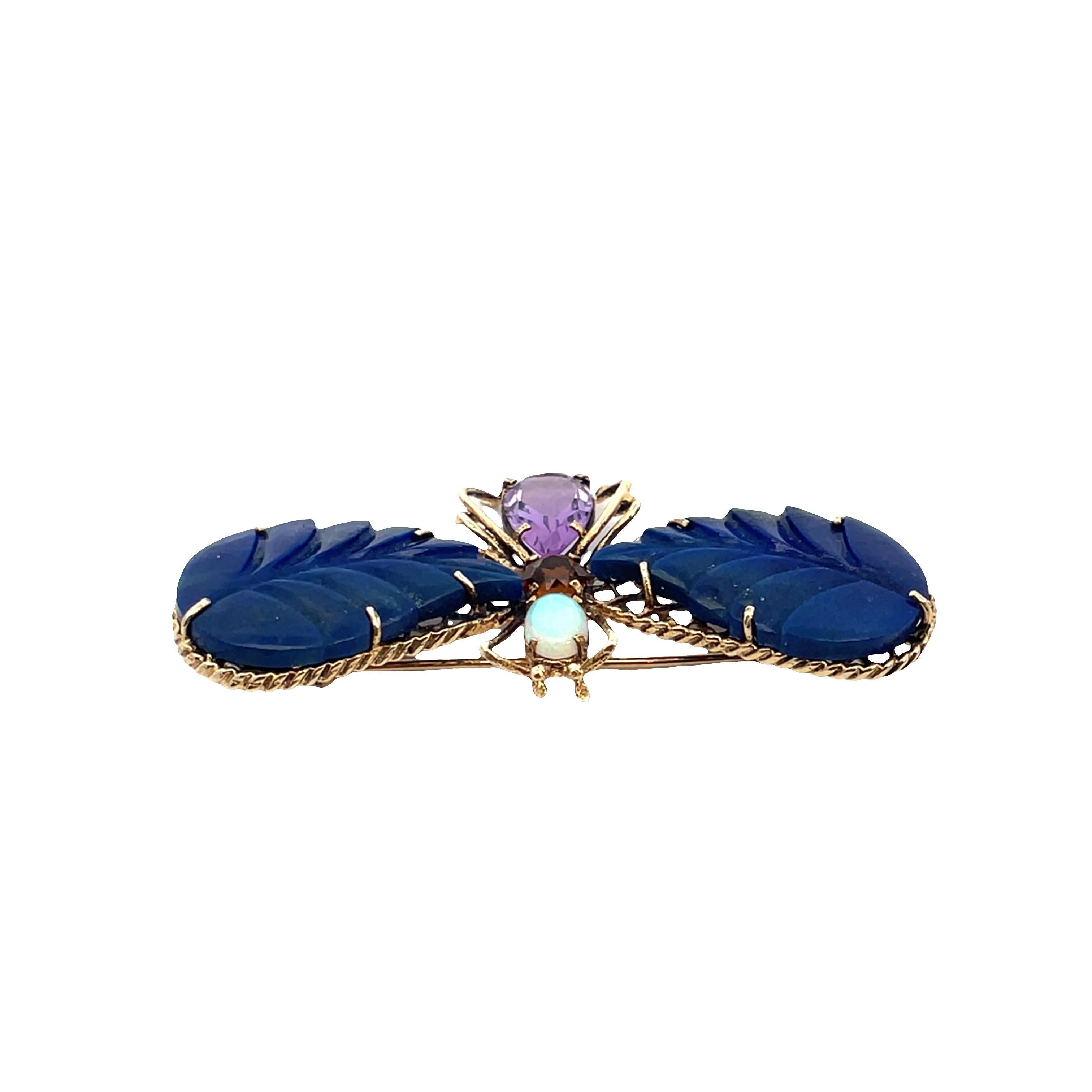 Rehaussez votre collection avec cette broche Butterfly, réalisée en or jaune 14 carats. La pièce centrale présente une paire d'ailes en lapis bleu vibrant, taillées dans un style mixte pour créer un design captivant. Les pierres primaires sont