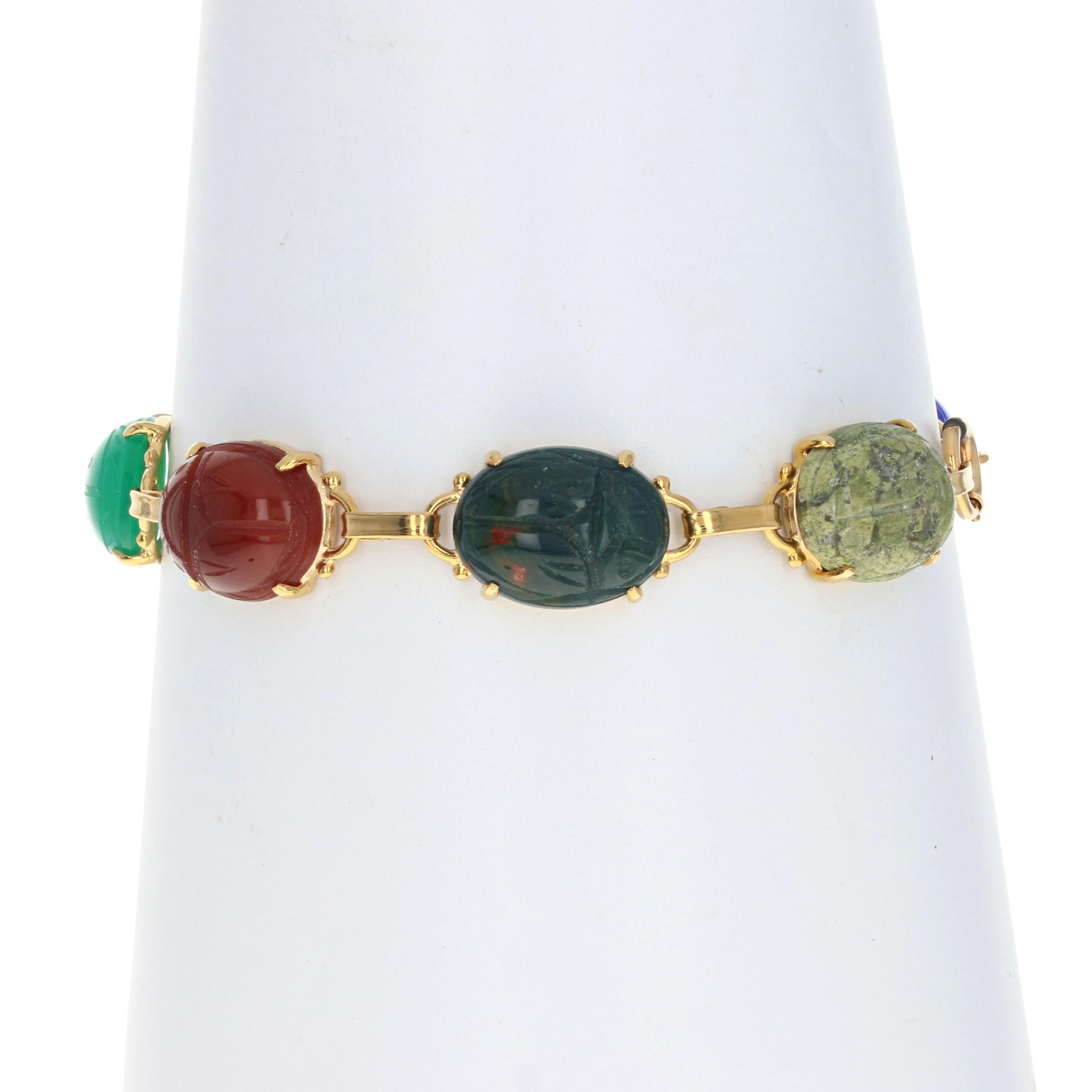 With bold color and refined style, this exquisite bracelet is destined to become a signature piece in your jewelry collection! This 14k yellow gold link bracelet showcases seven eye-catching gemstone cabochons which display carved scarab beetles