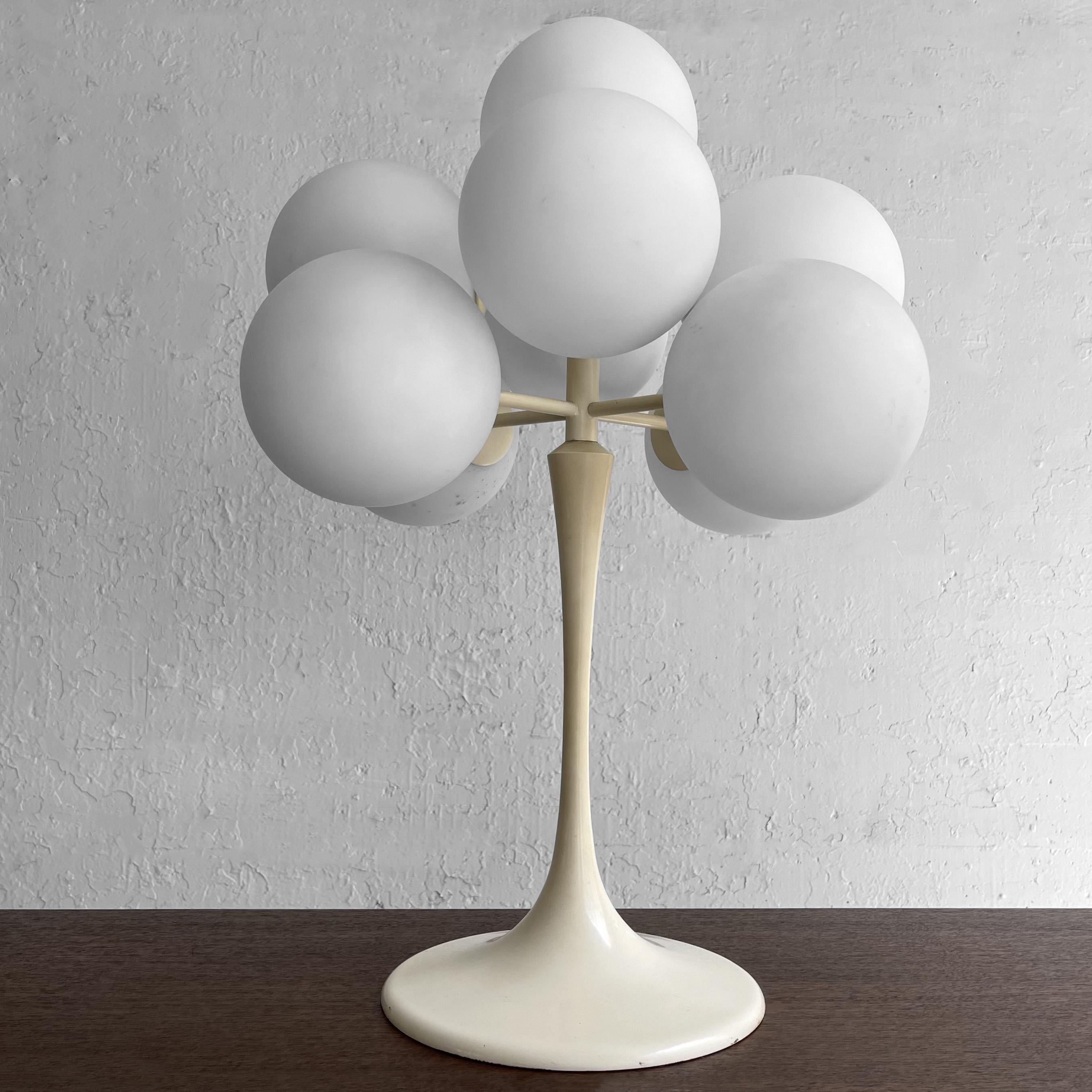 Multi Globe “Figuration” table lamp designed by Eva Renée Nele for German-Swiss lighting manufacturer Temde Leuchten features an enameled metal tulip base with a cluster of nine frosted glass globes. Collectible, statement lighting.