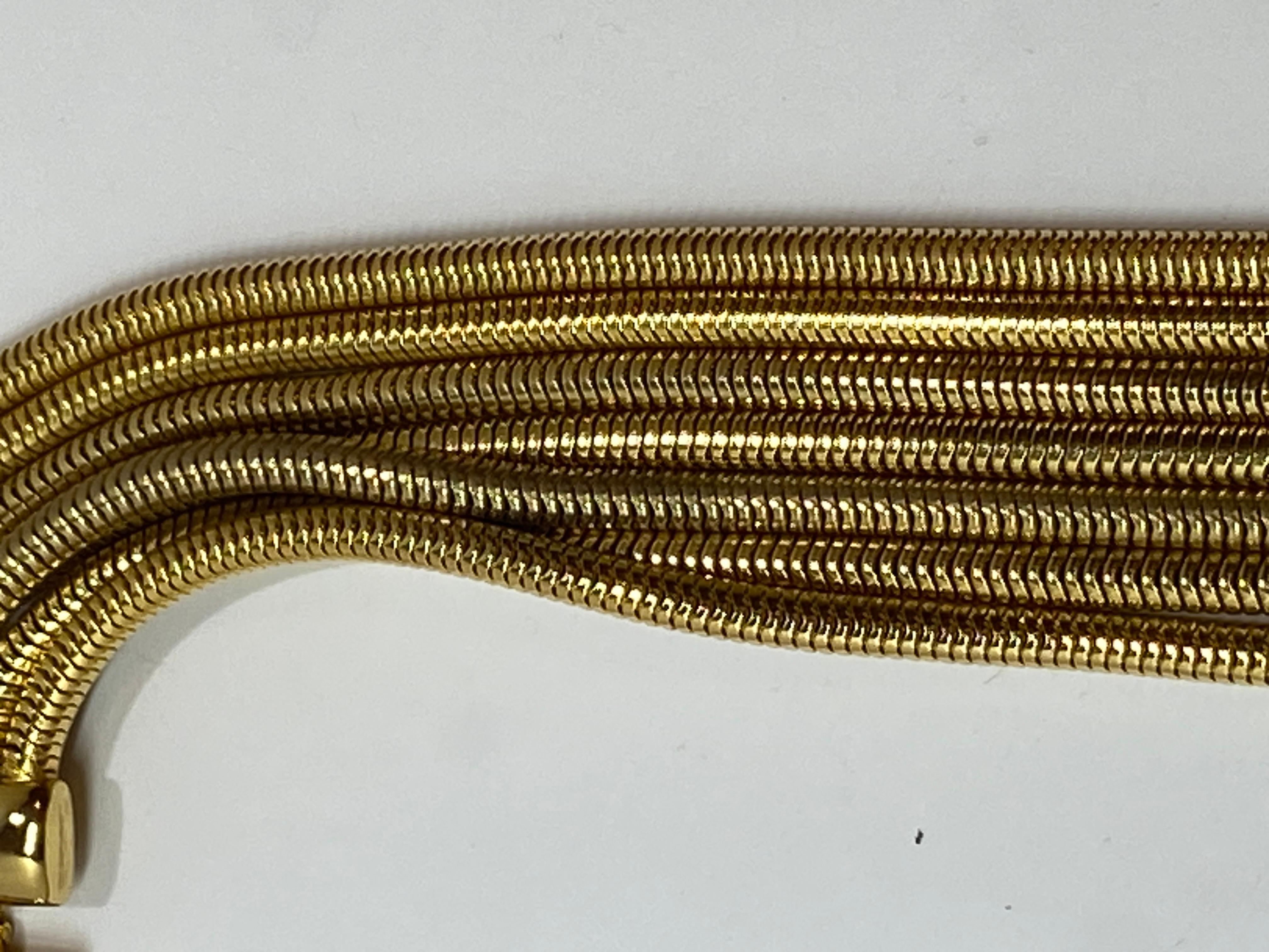 This wonderfully elegant smooth multi-linked snake-link polished gold hardware necklace measures 16 inches at the shortest to 21 inches. Necklace lays comfortably smooth along the neck. The width measures 1 1/4 inches. The closing is a 'snap'