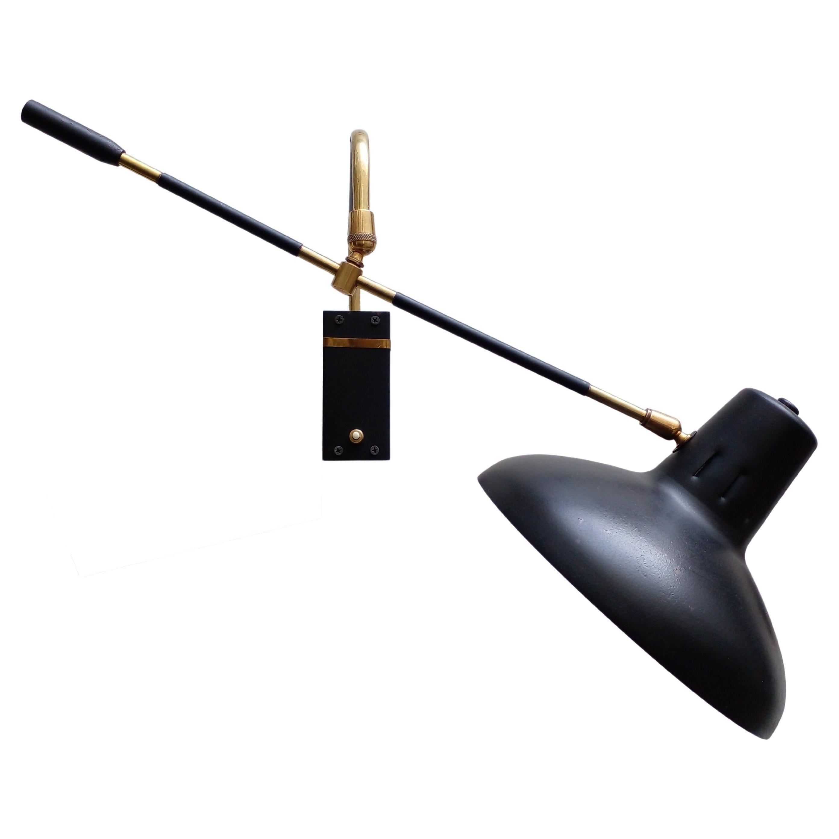 Multi-adjustable wall lamp in black lacquered iron and brass, Italy around 1950. 
The arm fixed to the wall plate swivels to 380° and the adjustable light arm has two ball joints.
Lampshade is lacquered in white color.