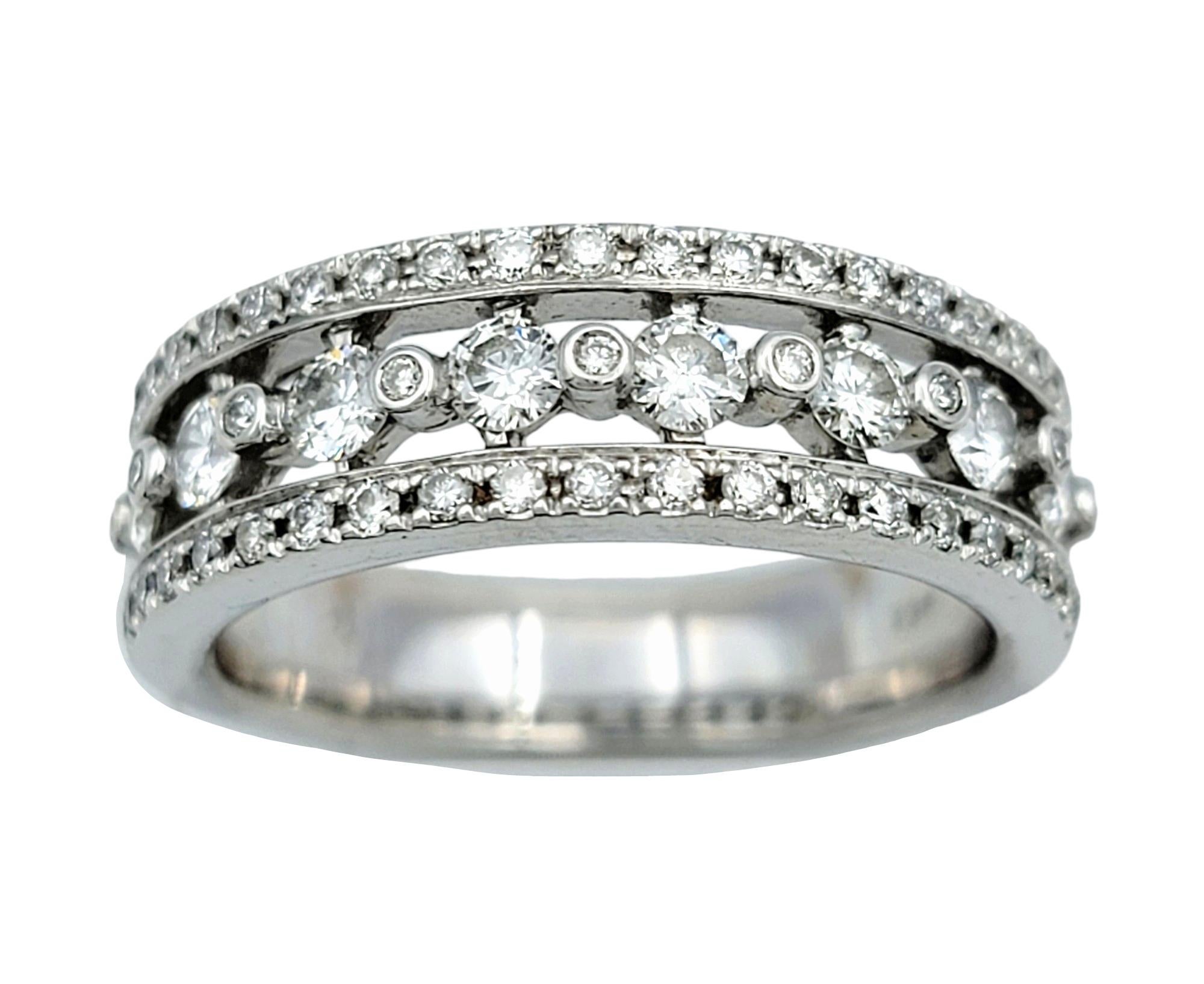 Ring Size: 6.5

This diamond band ring, crafted in 14 karat white gold, is a dazzling display of elegance and sophistication. Its design features a row of round diamonds of varying sizes meticulously set in a continuous line, creating a radiant