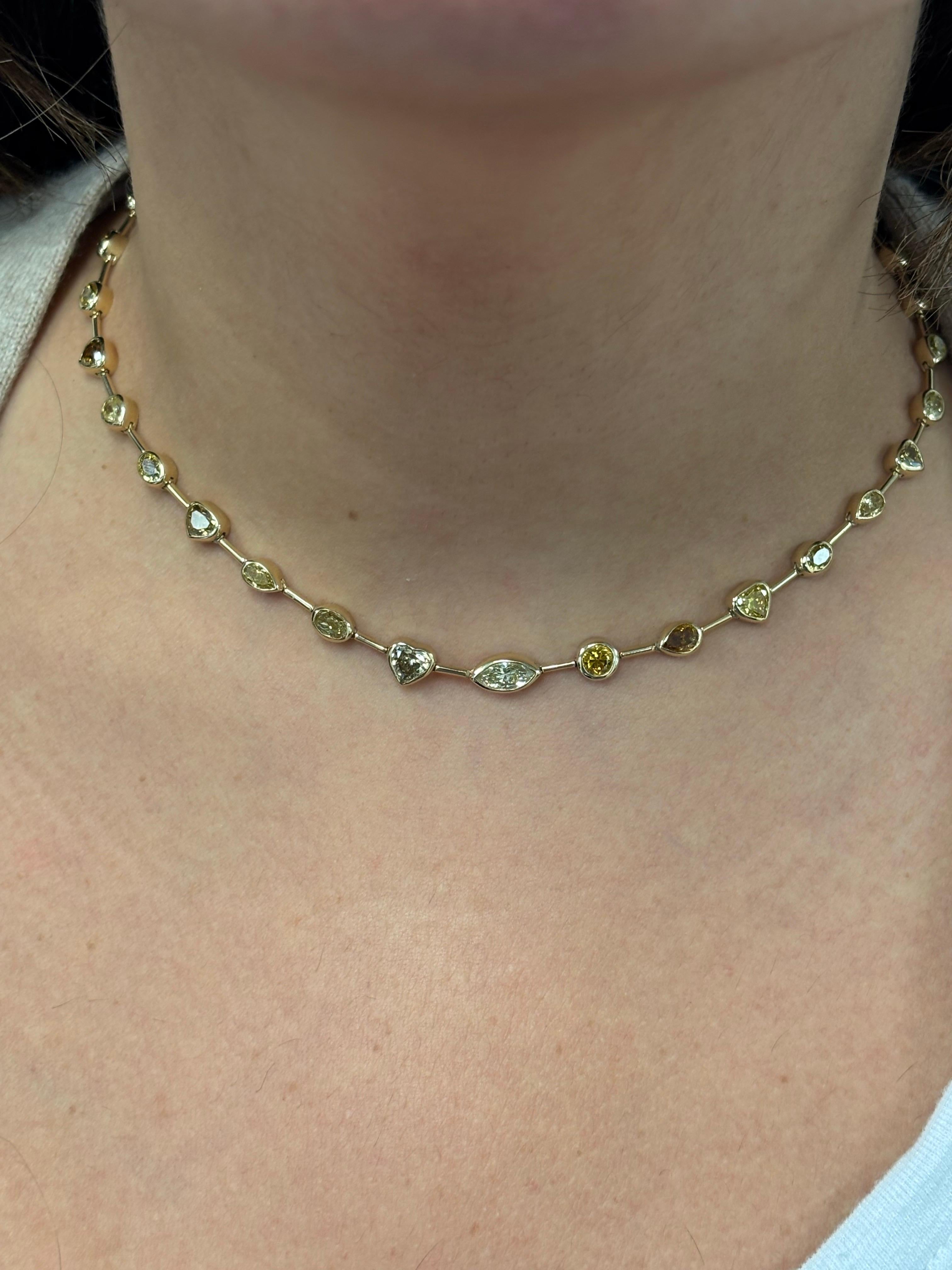 Collana con zaffiri multipli incastonati in oro giallo 14K. Questa collana è incastonata con pietre a forma di cuore, ovale, marquise, pera e rotonda. Il peso totale della collana è di 10,56 carati. La lunghezza è di 16 pollici.