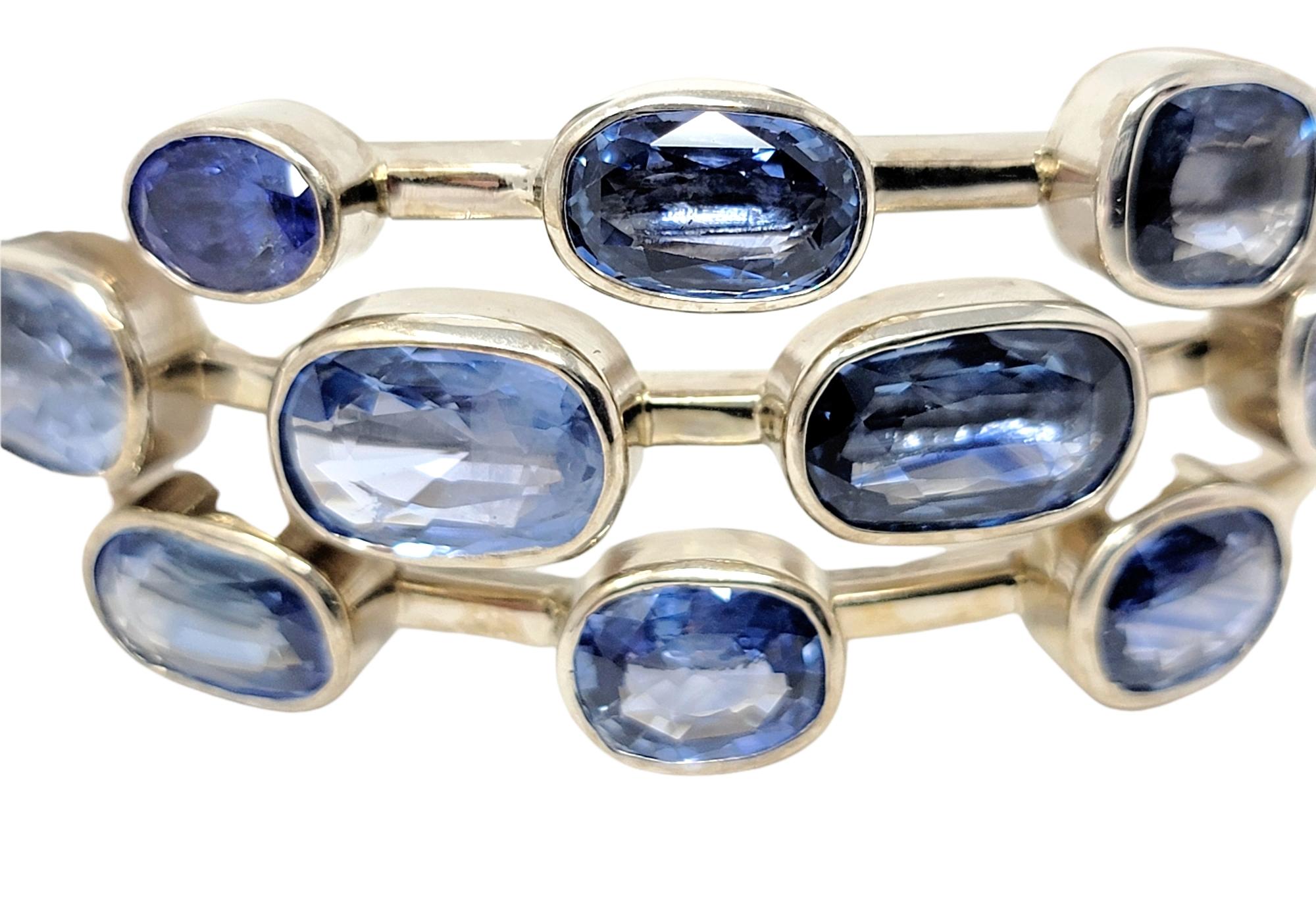 If blue is your color, than this is the bracelet for you! Absolutely stunning, one-of-a-kind blue gemstone bangle filled with 10 colorful stones, all in a slightly different shade of blue. 9 natural sapphires and 1 tanzanite stone are all bezel set