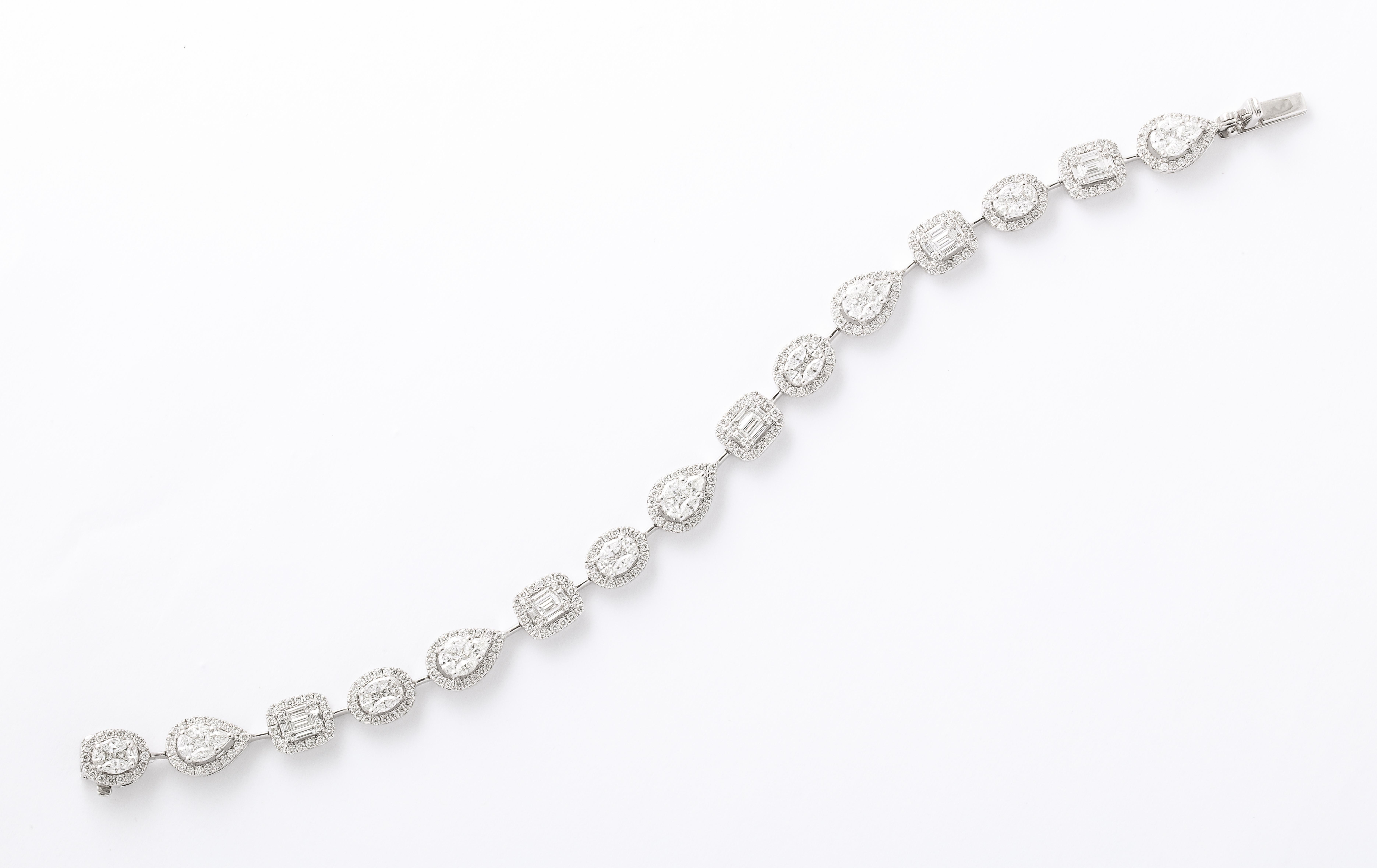 A beautiful multi shape bracelet made of illusion set diamonds. 

5.15 carats of white diamonds.

18k white gold 

6.75 inch length. 