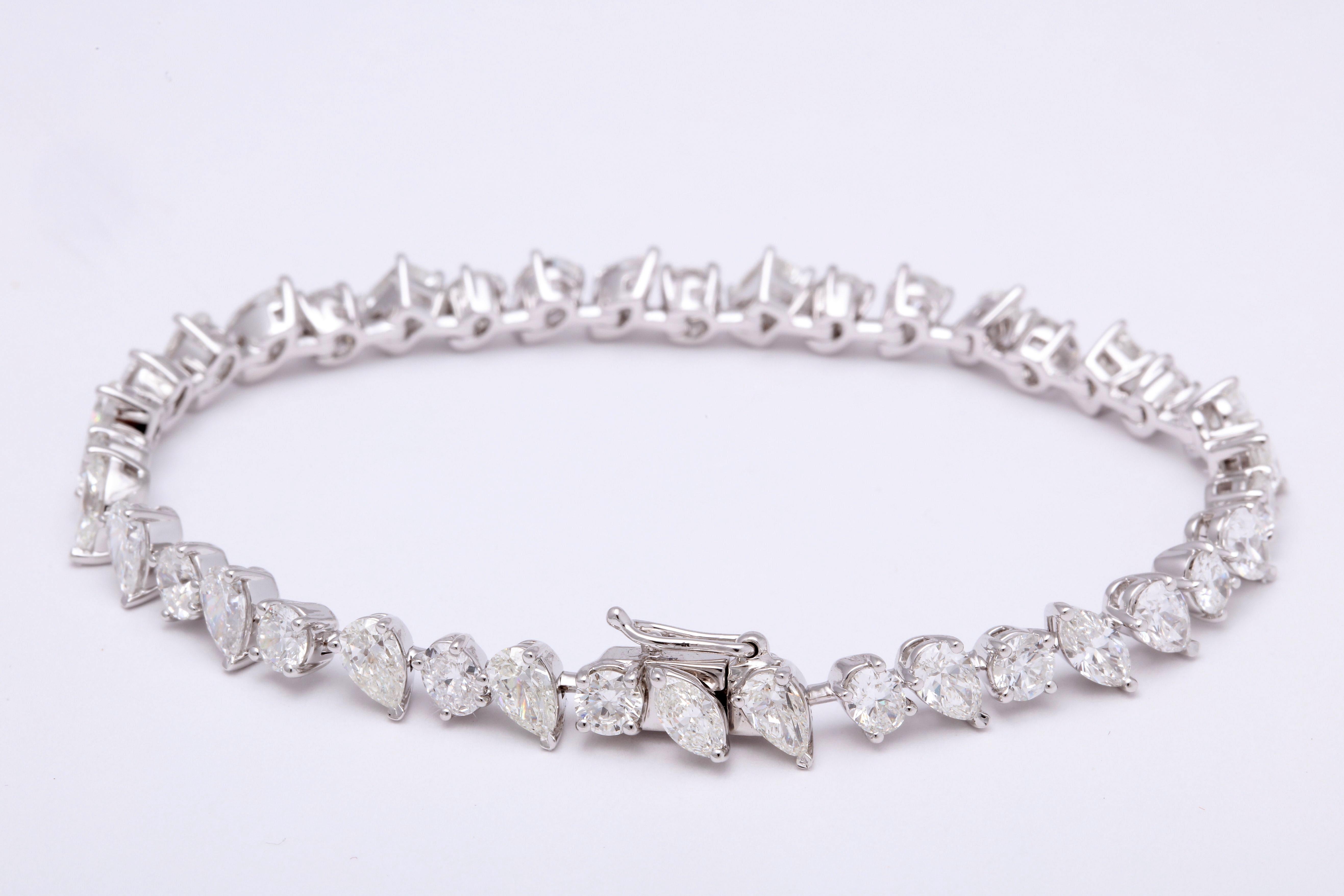 
A beautiful and unique tennis bracelet!

Gorgeous on its own and stacked with other bracelets.

10.07 carats of white diamonds set in 18k white gold.

The bracelet features round, pear, oval, marquise and emerald cut diamonds. 

6.75 inch length 