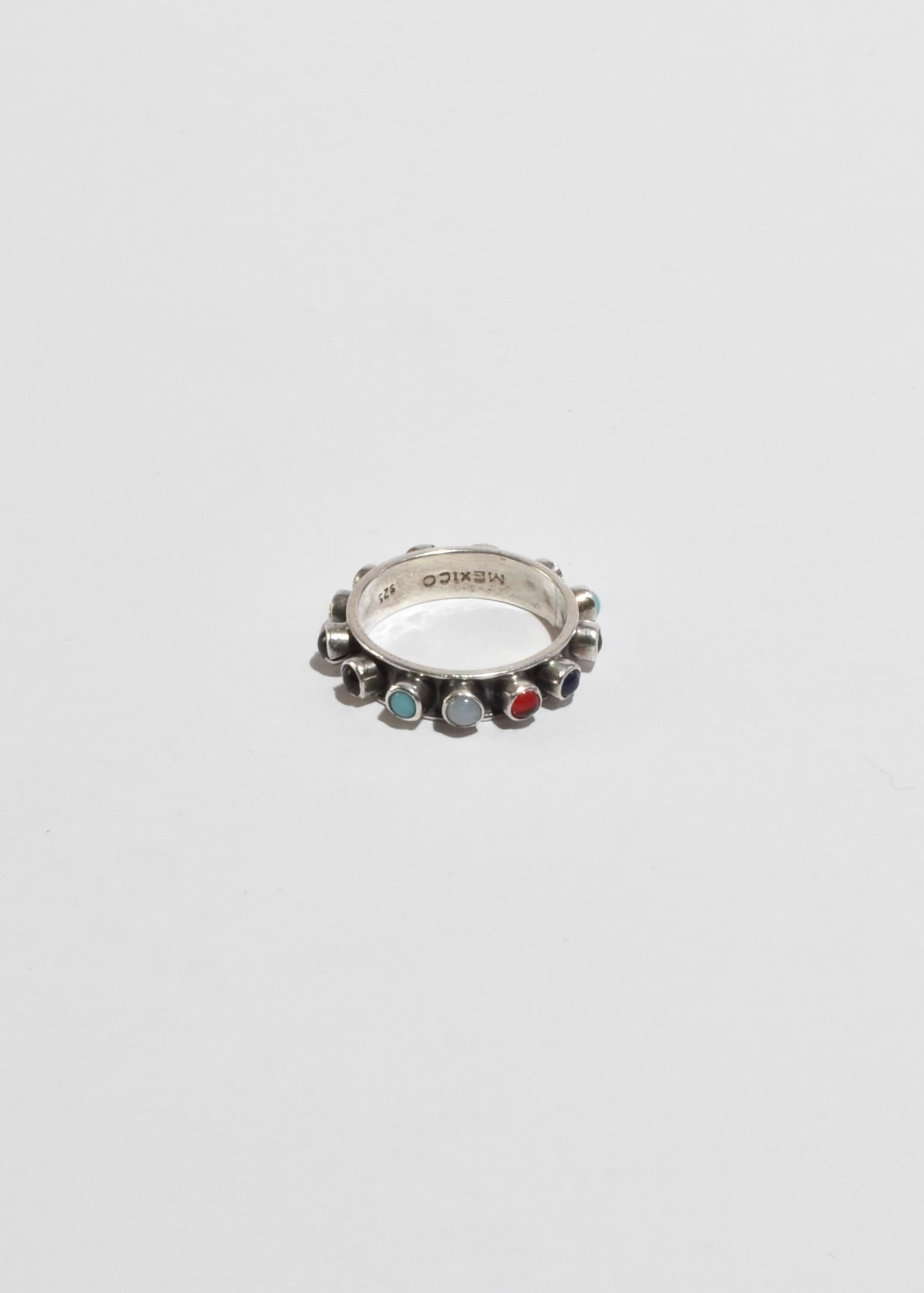 Vintage sterling band ring with petite round colorful cabochons. Stamped Mexico, 925.

Material: Sterling silver, turquoise, onyx, lapis lazuli, moonstone, garnet, quartz.