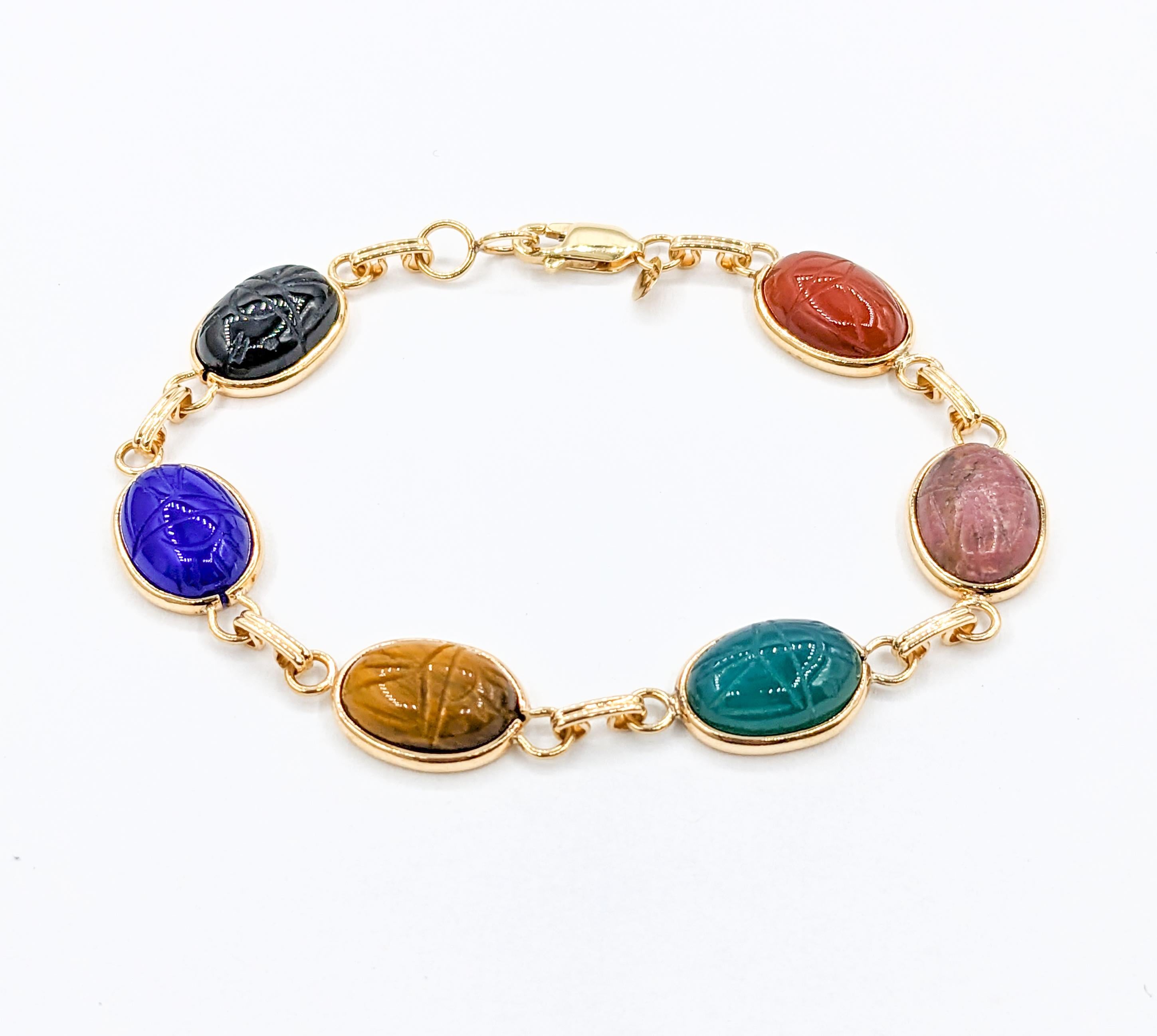 Multi Stone Scarab Bracelet in Yellow Gold 

Introducing a stunning Scarab Bracelet, meticulously crafted in 14kt Yellow Gold, adorned with an array of exquisite Multiple gemstones. The Bracelet Scarab features a distinctive carved detail. Sized at