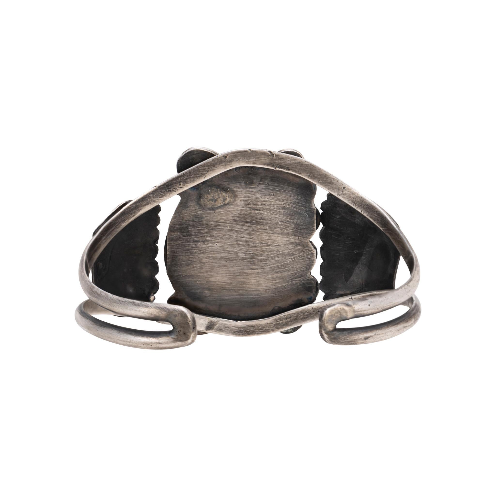 Bracciale multipietra in argento sterling. Composizione centrale con turchese Kingman tagliato a triangolo, ramo di corallo rosso e piccola madreperla a taglio rotondo. Ciascuno di essi è incastonato in un castone a dente di sega  con accenti di