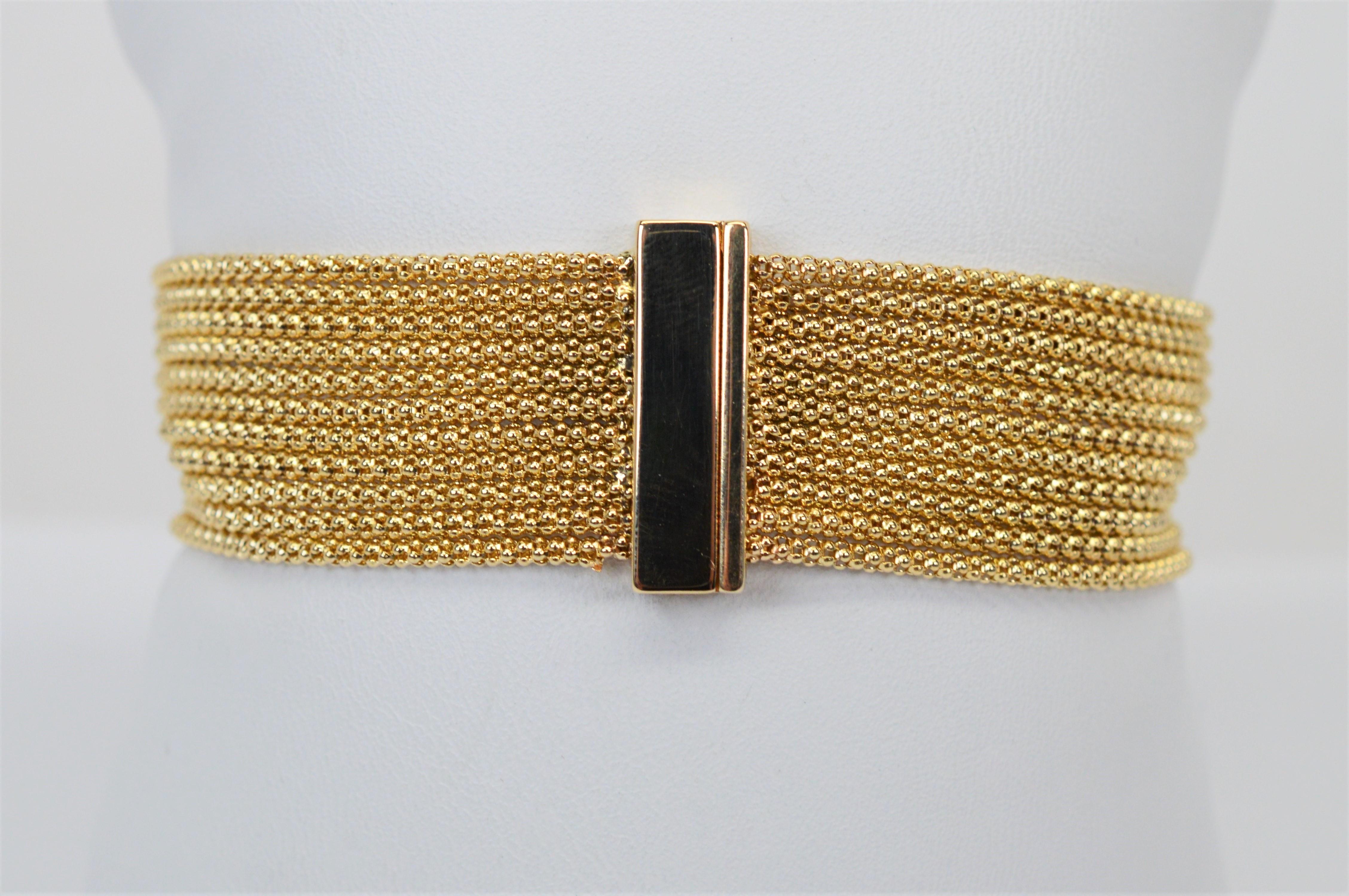 Eleven strands of fourteen karat 14k yellow gold mesh chain fluidly drape the wrist with understated elegance interrupted only by the sleek fourteen karat 14k gold bar detail which duals as a convenient magnetic closure for this fabulous piece.