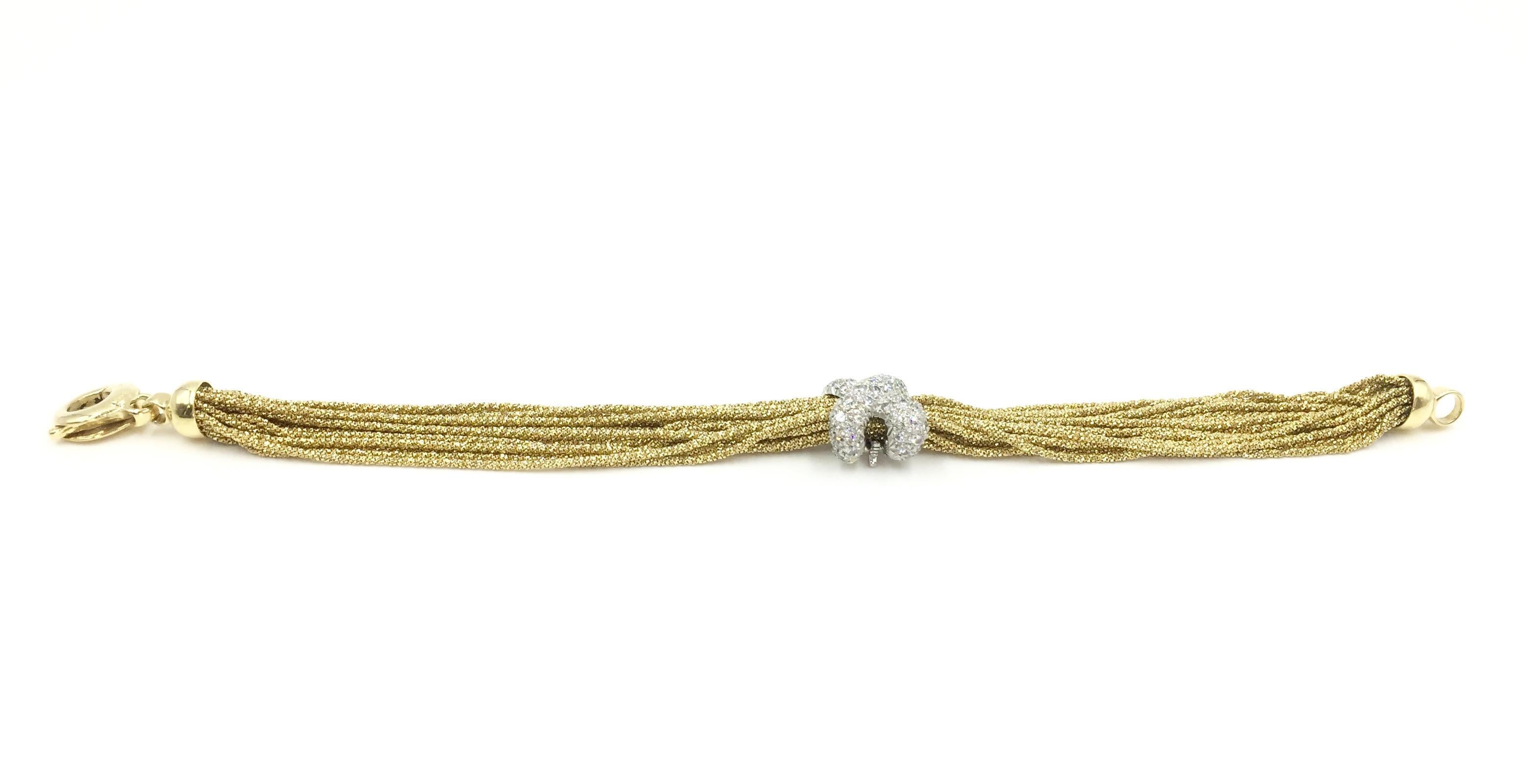 Signed Yuri Ichihashi. Twenty sparkling strands of 18 karat yellow gold hand woven chains make this bracelet eye catching yet wearable from day to evening. Removable platinum X shaped enhancer is pavé set with 1.15 carats of round brilliant diamonds