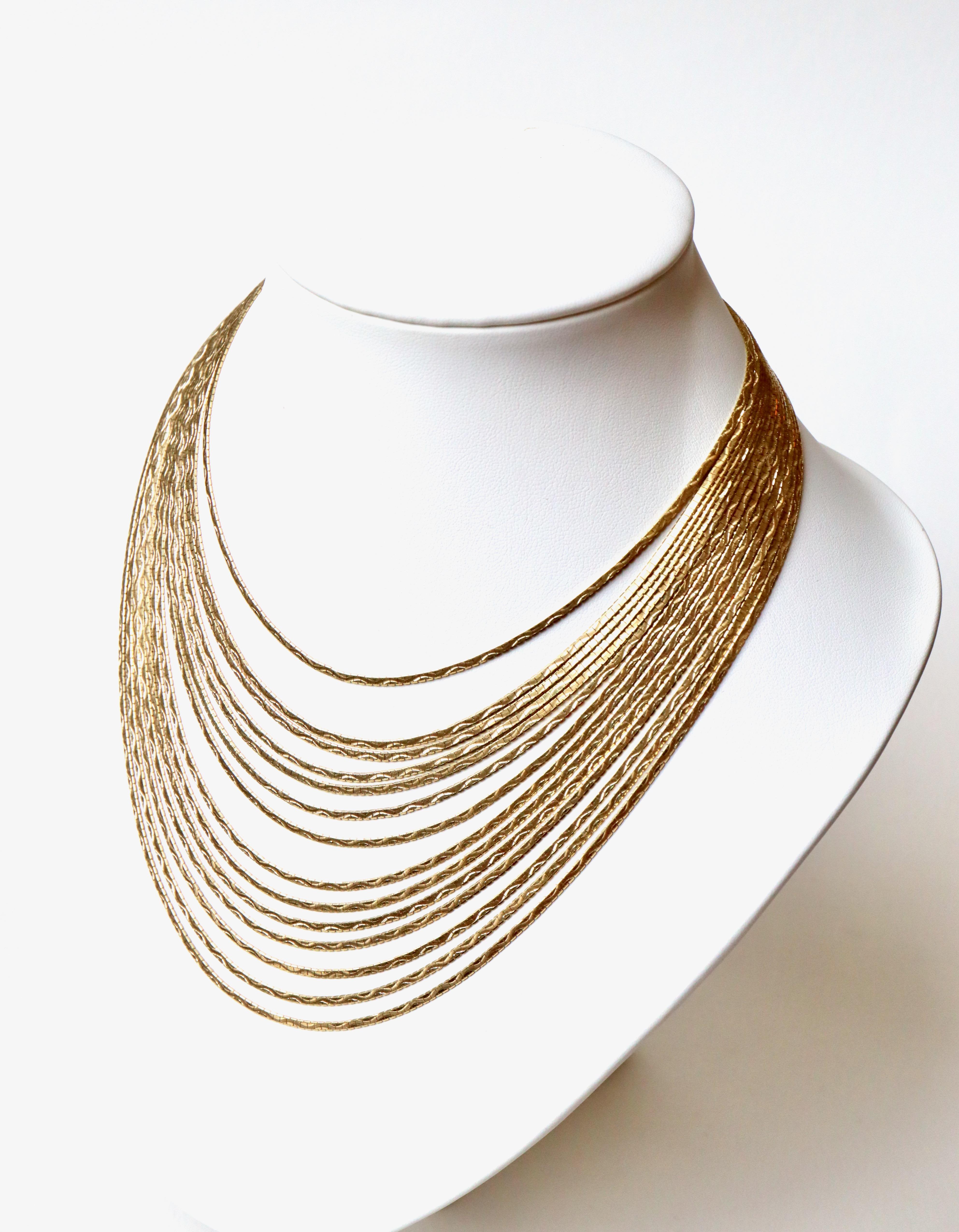 Multi-strand 18 kt yellow Gold Necklace composed of 14 Satin hinged 18 kt yellow Gold Wires. A Safety Eight. 18 Kt Gold Hallmark Eagle Head
Net weight: 101.5g
Length 37 cm at the smallest Wire and 50 cm at the largest.