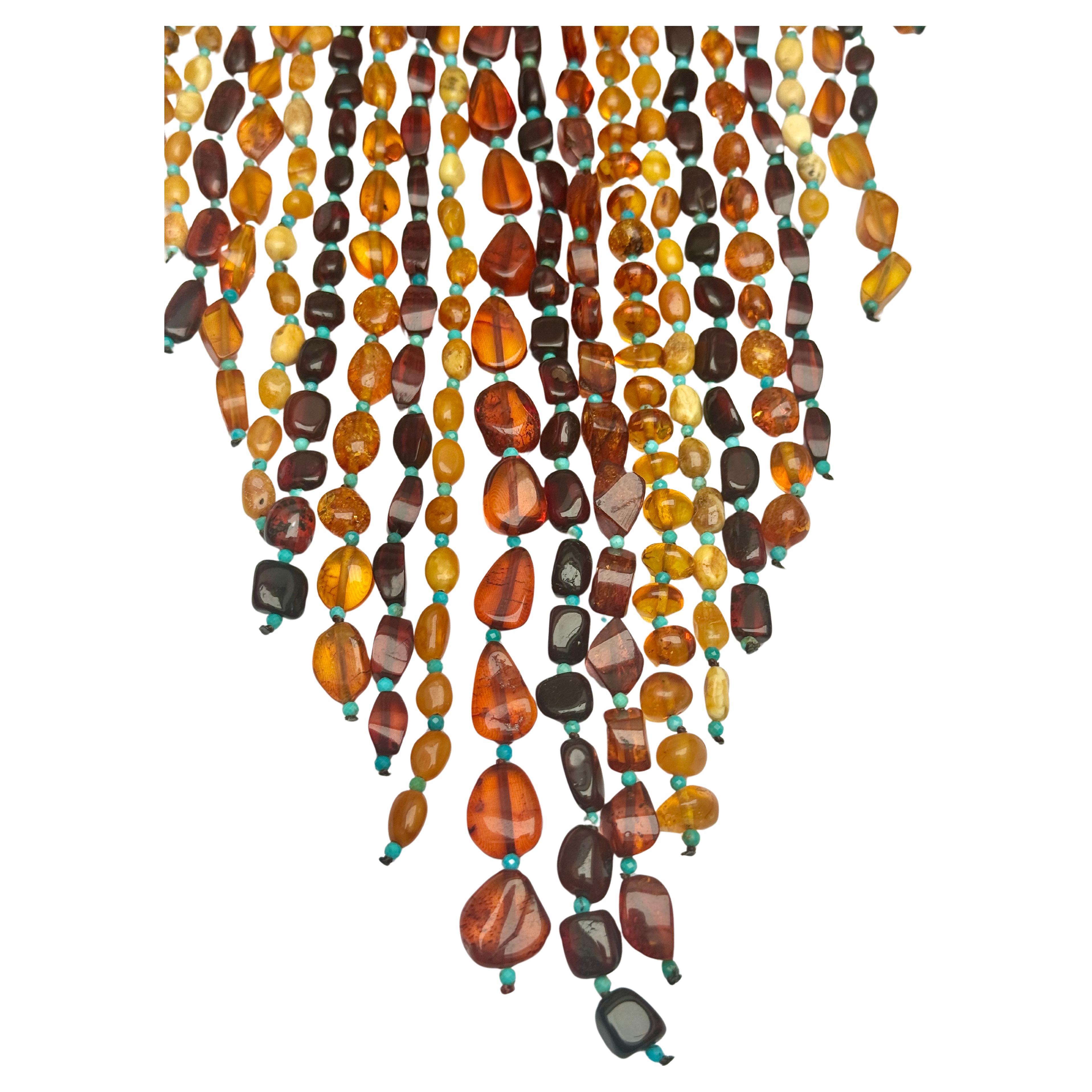 Collana lunga in ambra baltica naturale e turchese a più fili.
Splendida ed elegante collana d'ambra.  Perline d'ambra da chiare a scure, di dimensioni e forme medio-piccole, combinate con perline tonde di turchese naturale. Lunga circa 24,5 pollici