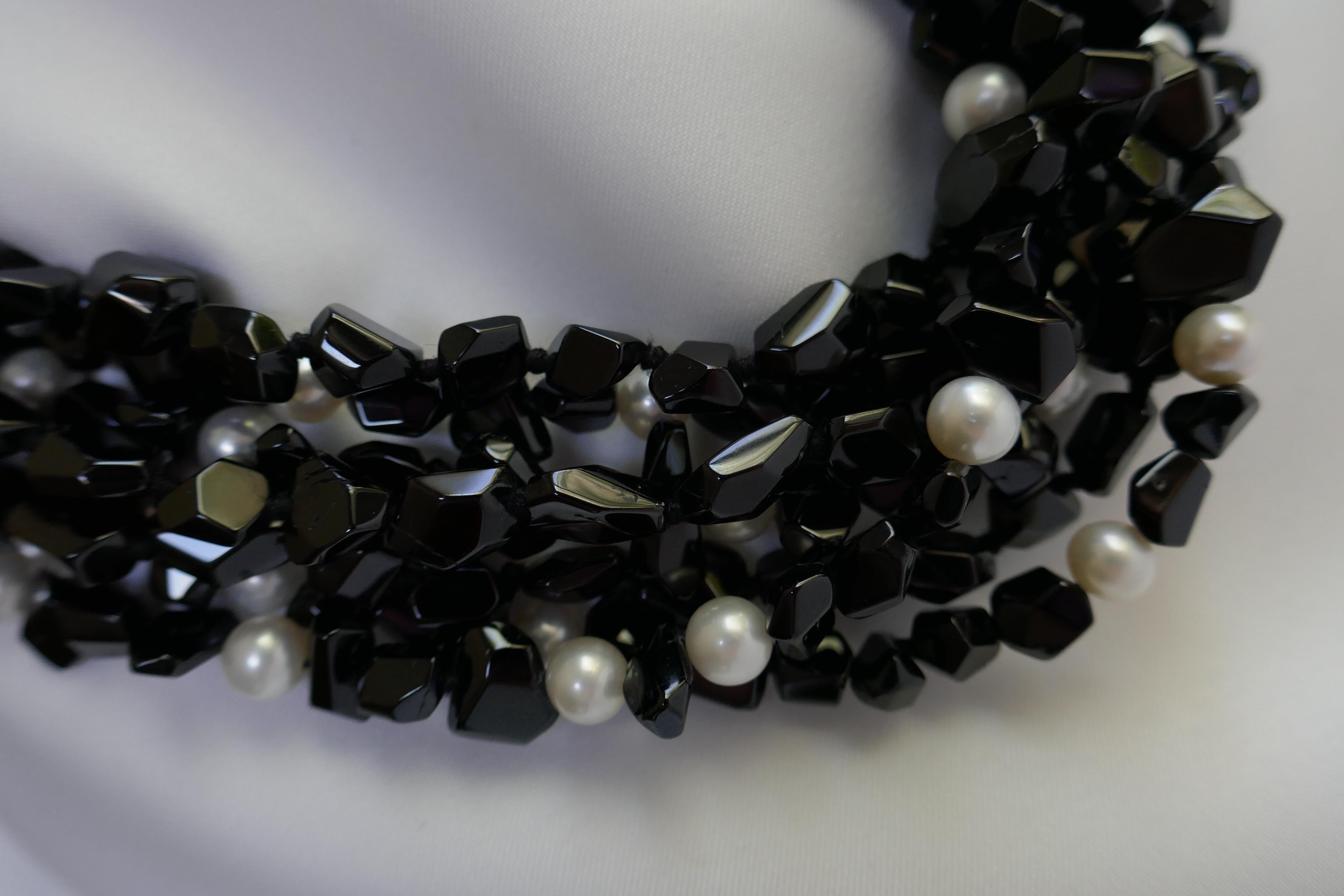 This black spinel nugget and white cultured pearl is a seven strand statement necklace. The white cultured (7.5mm-8mm) pearls are interspersed through out the necklace.  The necklace is individually knotted on black silk thread and has a 925