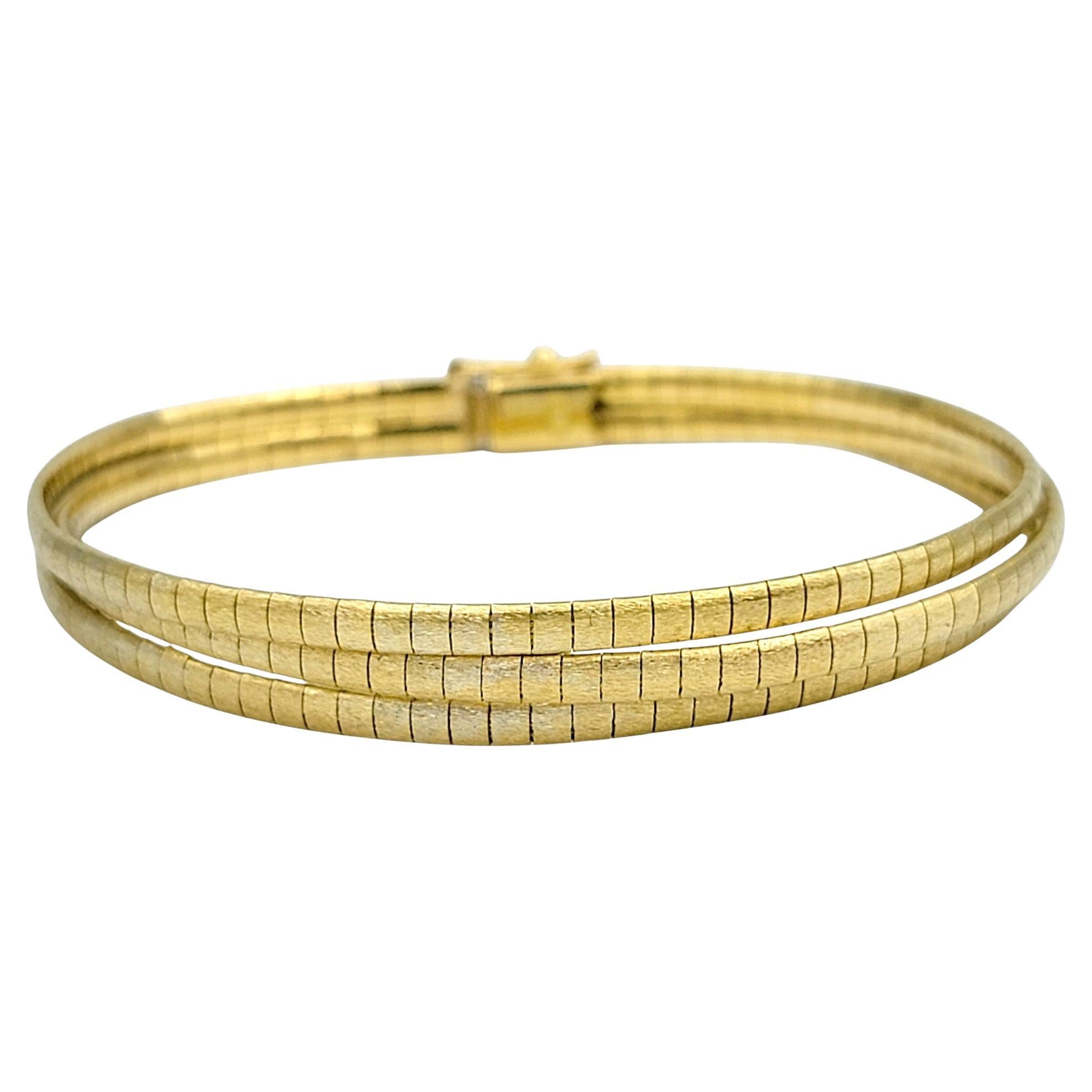 Faites preuve d'une sophistication intemporelle avec ce bracelet à maillons oméga multibrins, un chef-d'œuvre exquis en or jaune 18 carats. Chaque brin étincelant coule comme un soleil liquide, conçu de manière complexe pour créer une déclaration