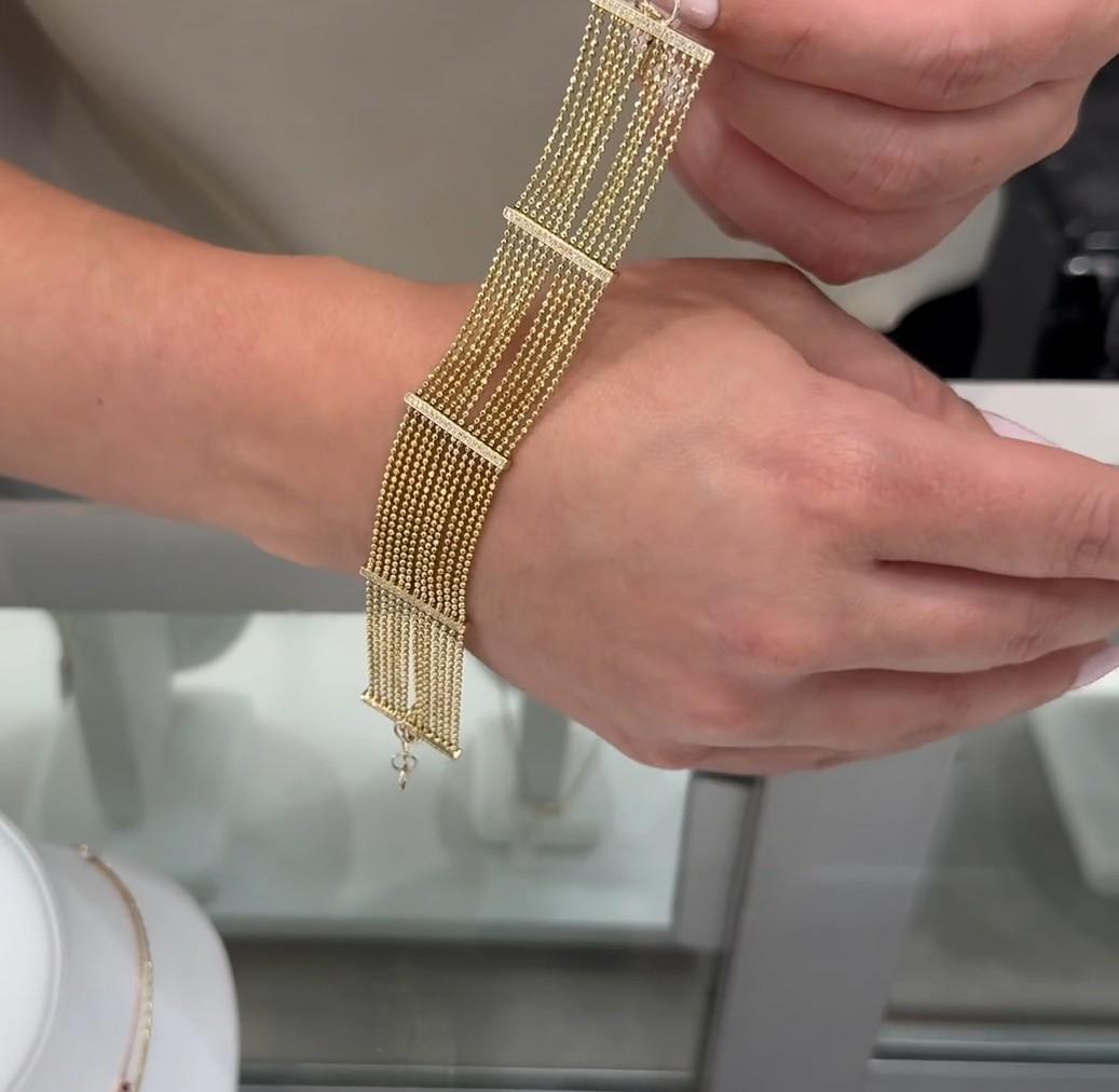 Pulsera ajustable de varias vueltas de oro amarillo de 14 quilates con 100 diamantes redondos que suman 0,30 quilates.

Esta pulsera está hecha de varios hilos de oro amarillo de 14 quilates, dispuestos uno al lado del otro para formar una banda