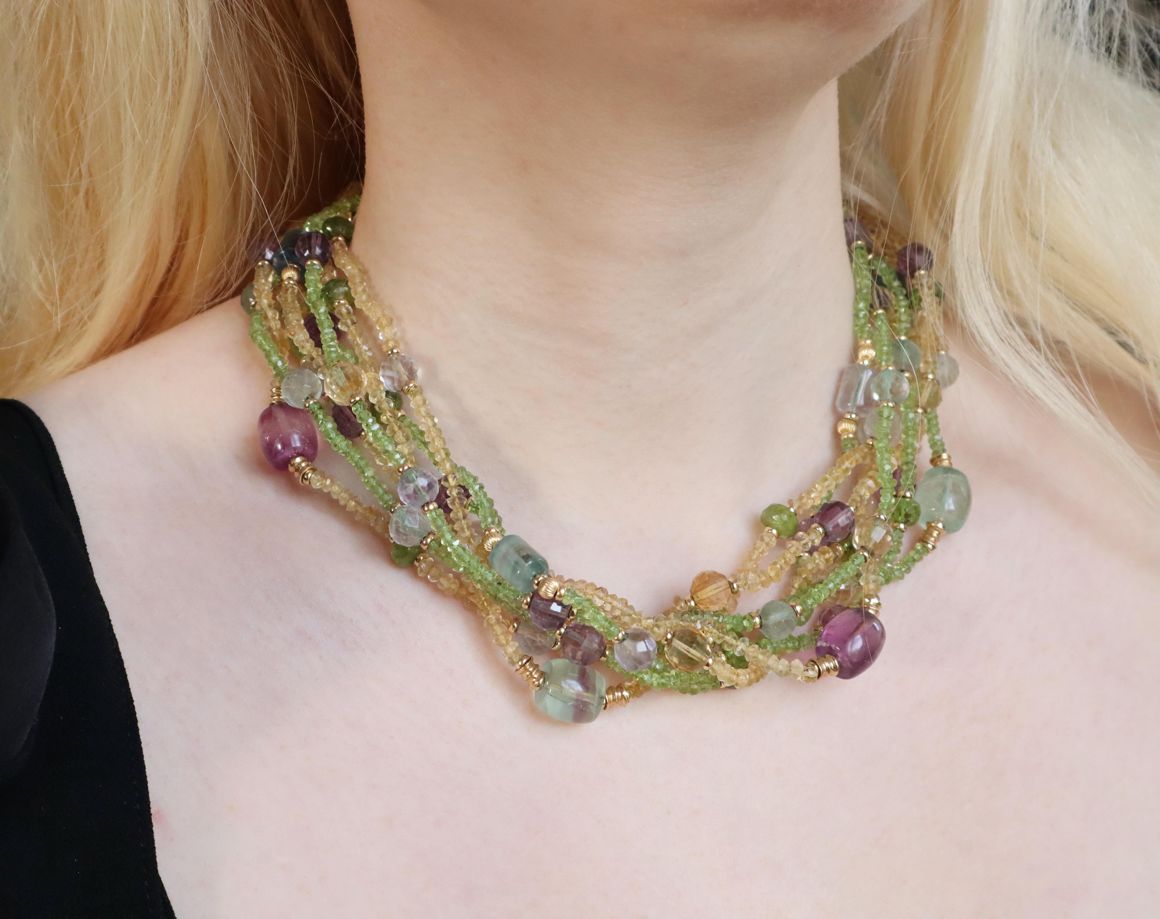 Eight row necklace in 18 kt yellow gold composed of amethysts, peridots, citrines. Citrine and peridot bead strands punctuated with large amethyst pearls and other fine stones, with 18 carats yellow gold balls and ferrules. 
Length 46 cm; width 4