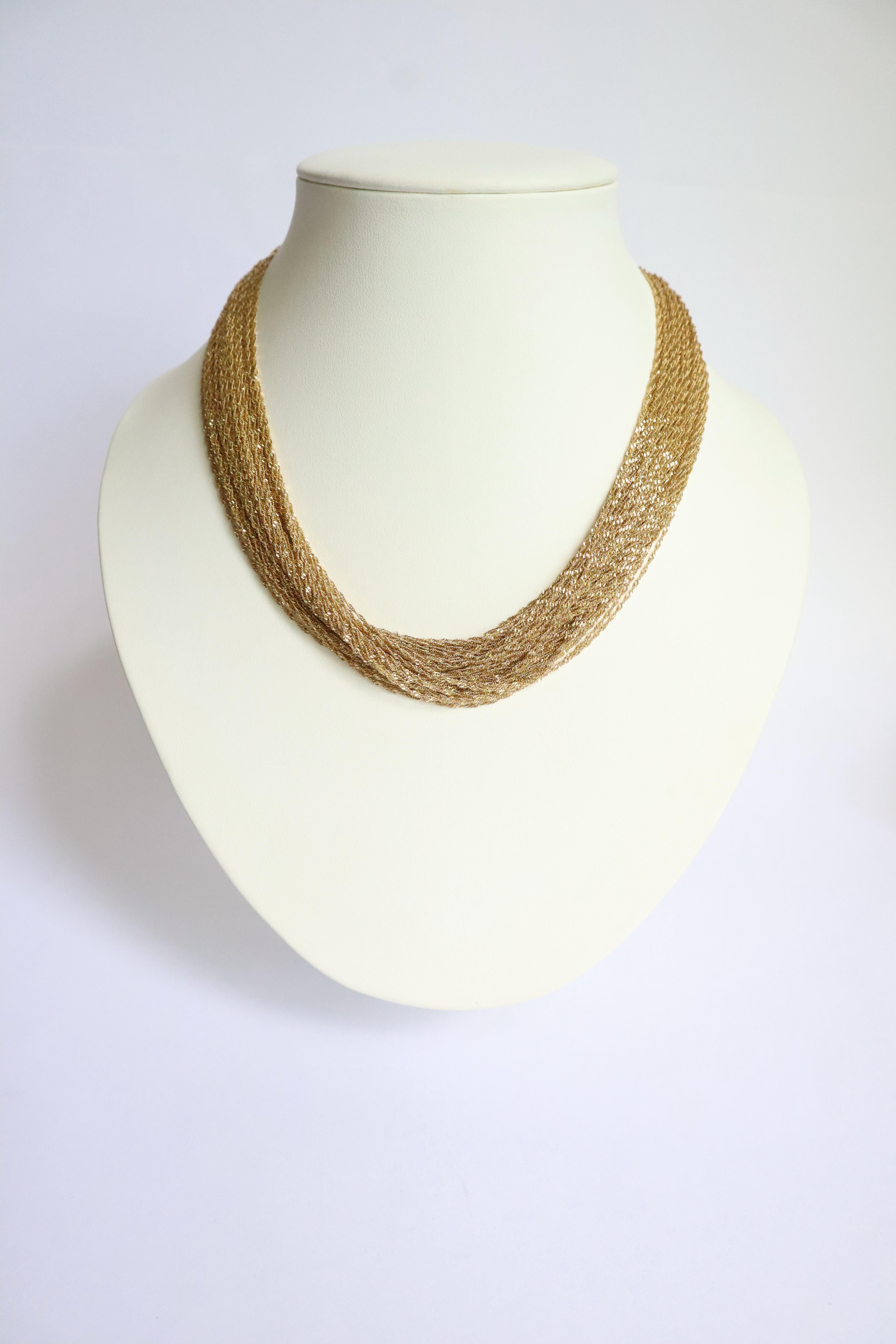 Mehrdrahtige Halskette aus 18 kt Gold. Es besteht aus 74 Ketten aus gedrehten Goldfäden. Dornschließe mit Sicherheits-Acht. 
Es ist möglich, es gelockt zu tragen, so dass es kürzer ist, oder nicht gelockt, so dass es länger ist. Bitte sehen Sie sich