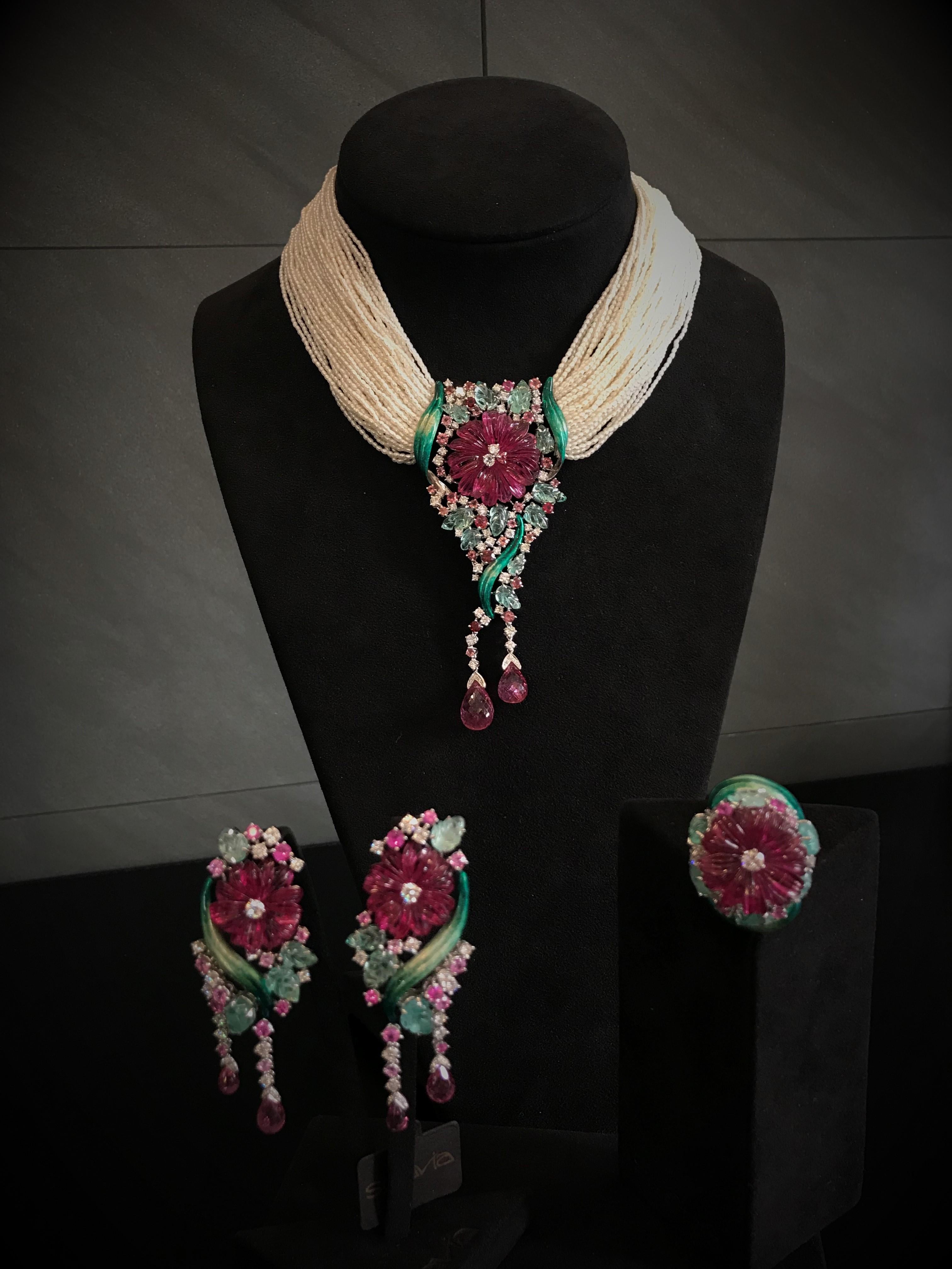 Almost a methaphysical flower for this necklace realized in white gold, pink rubelite flowers, briolette cut rubelites, emeralds leaves, round brilliant cut diamonds and pink tourmalines, green enamel and small pearls threads.
Diamonds total ct