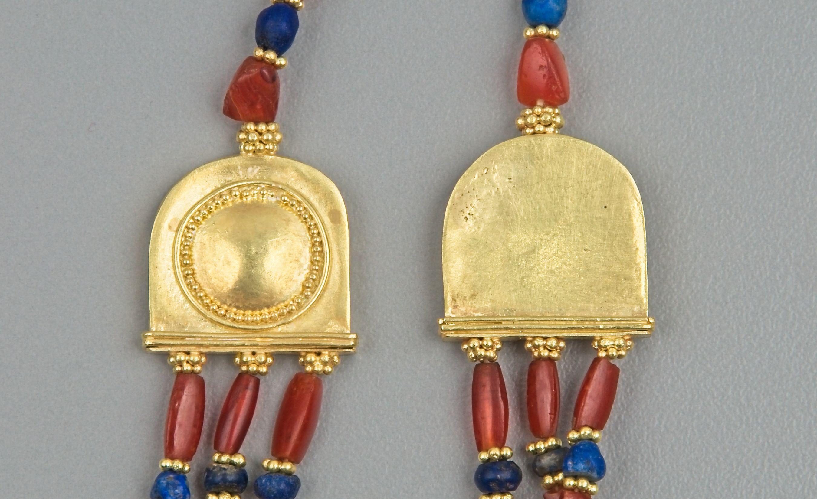 Eighty-six carnelian beads alternating with eighty-three lapis lazuli beads strung in three cascading strands: the stone beads are all alternating with 20k gold granulated ring beads. There are two gold terminals into which the three strands, each 4
