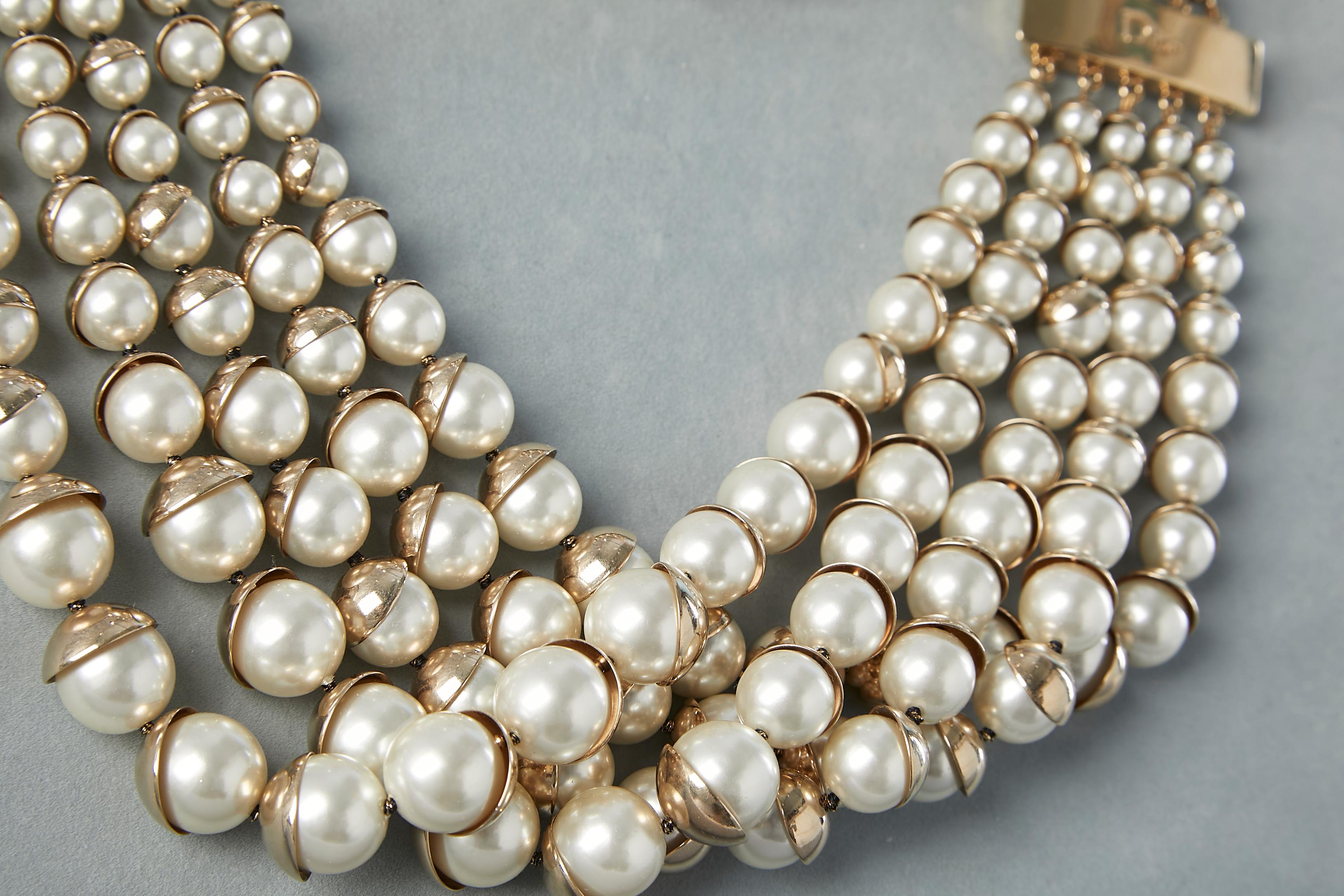 Mehrreihiges Collier mit Perlen. Goldfarbene Metallschließe. Box und Koffer werden mitgeliefert.
Durchmesser = 48 cm