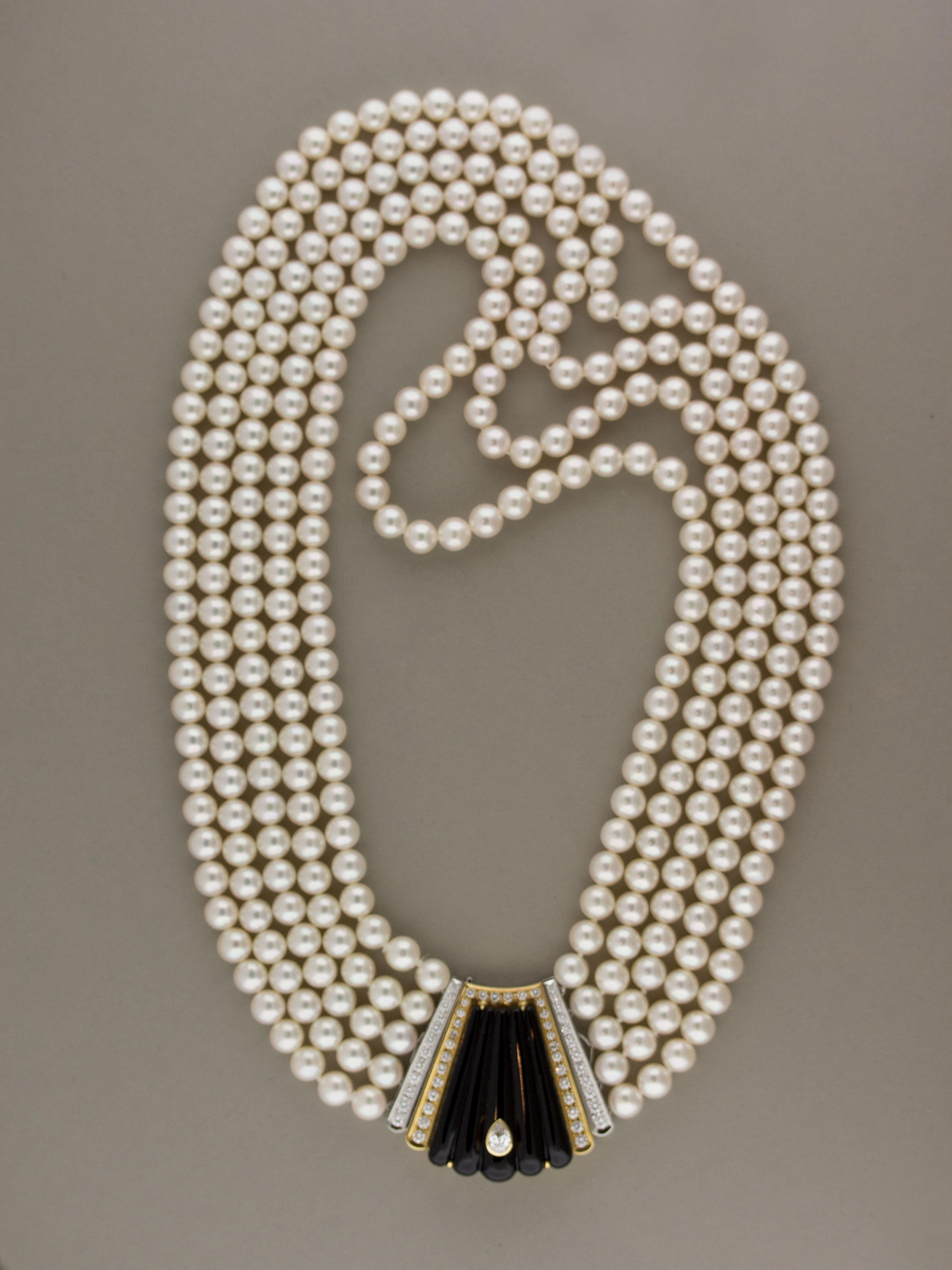 Five strands of round sweet pearls make the necklace of this wonderful piece. The center piece, made of 18k yellow gold and platinum, features a large black onyx with a 0.25 carat pear shape diamond set inside it. Around there are an additional 2.95