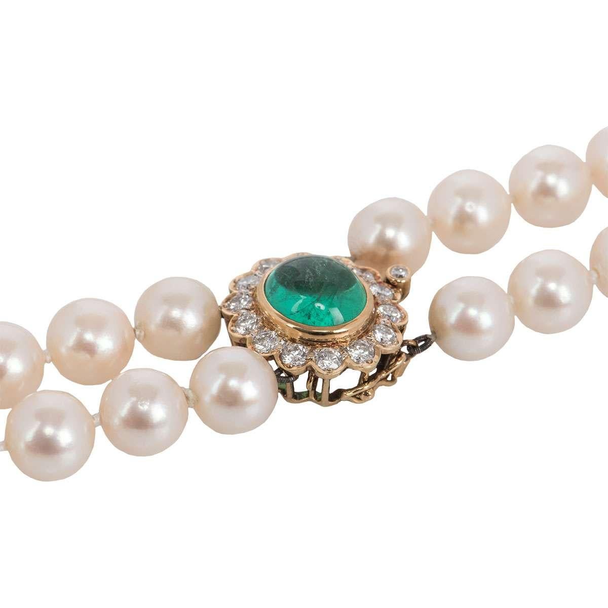 A beautiful 18k yellow gold diamond, emerald and pearl necklace. The necklace is comprised of 2 graduated strands of 166 individually knotted 9mm cultured pearls. The pearls display a cream body colour with pink overtones. The clasp features a