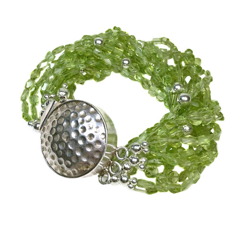 This is a twelve strand peridot bracelet created by Noveau Boutique. Daisy had to take much time to work with these tiny (average 3 by 5 mm) faceted variable shaped translucent peridot gemstone beads. Some 5 mm sterling balls and other sterling