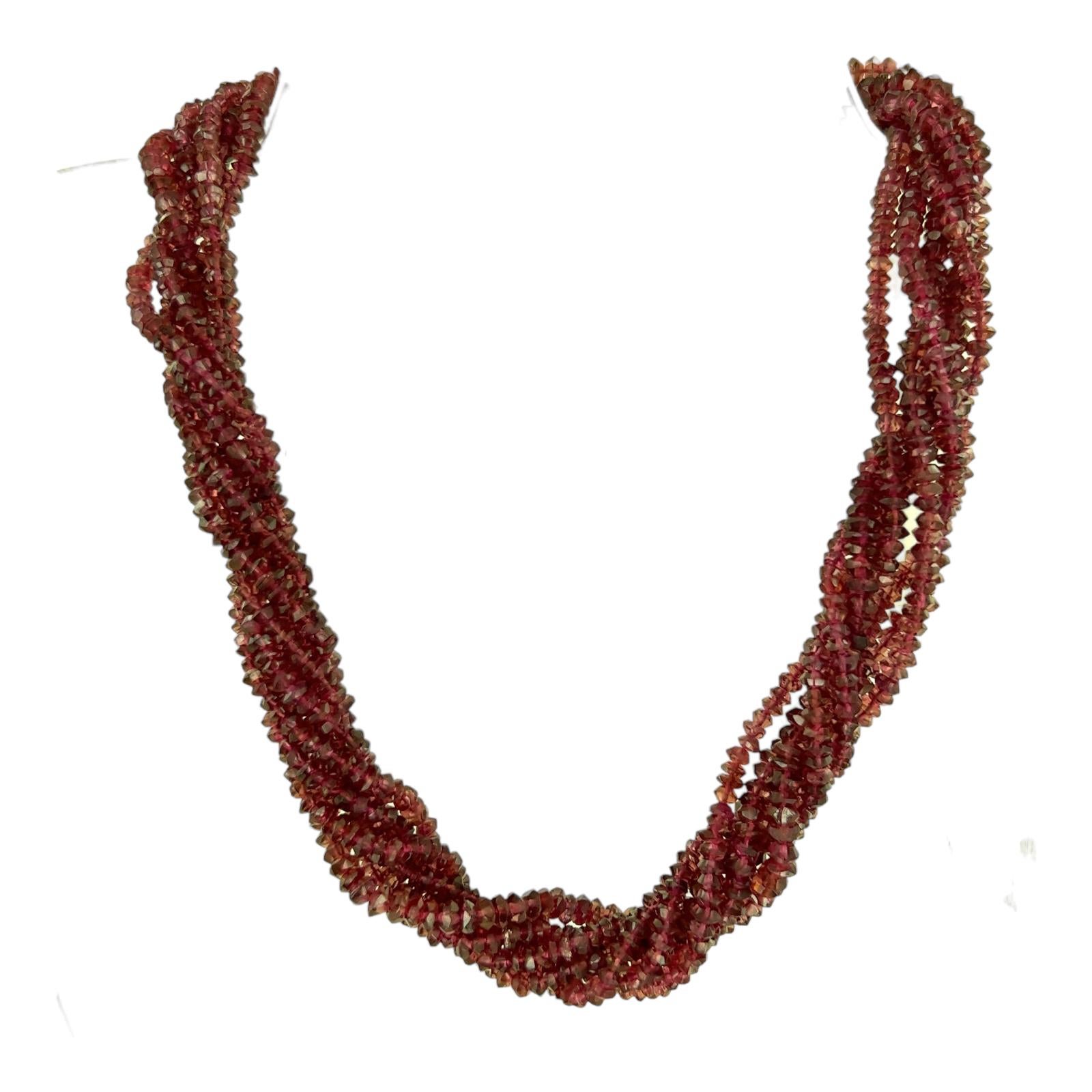 Seven strand ruby bead necklace handcrafted wtih a 14 karat yellow gold hook clasp. The necklace features 7 strands of natural ruby gemstone beads and measures 16 inches in length. Hand crafted gold clasp. 