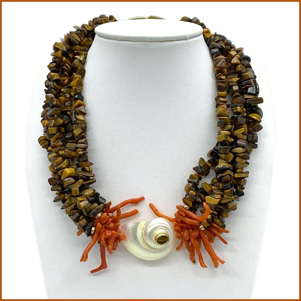 This is a multi-strand Tiger's Eye necklace. It's studio jewelry made with five strands of tiger's eye chips and a gilt hook clasp. The necklace comes with natural coral branches and a shell as the focal point.

Our vintage jewelry collection and